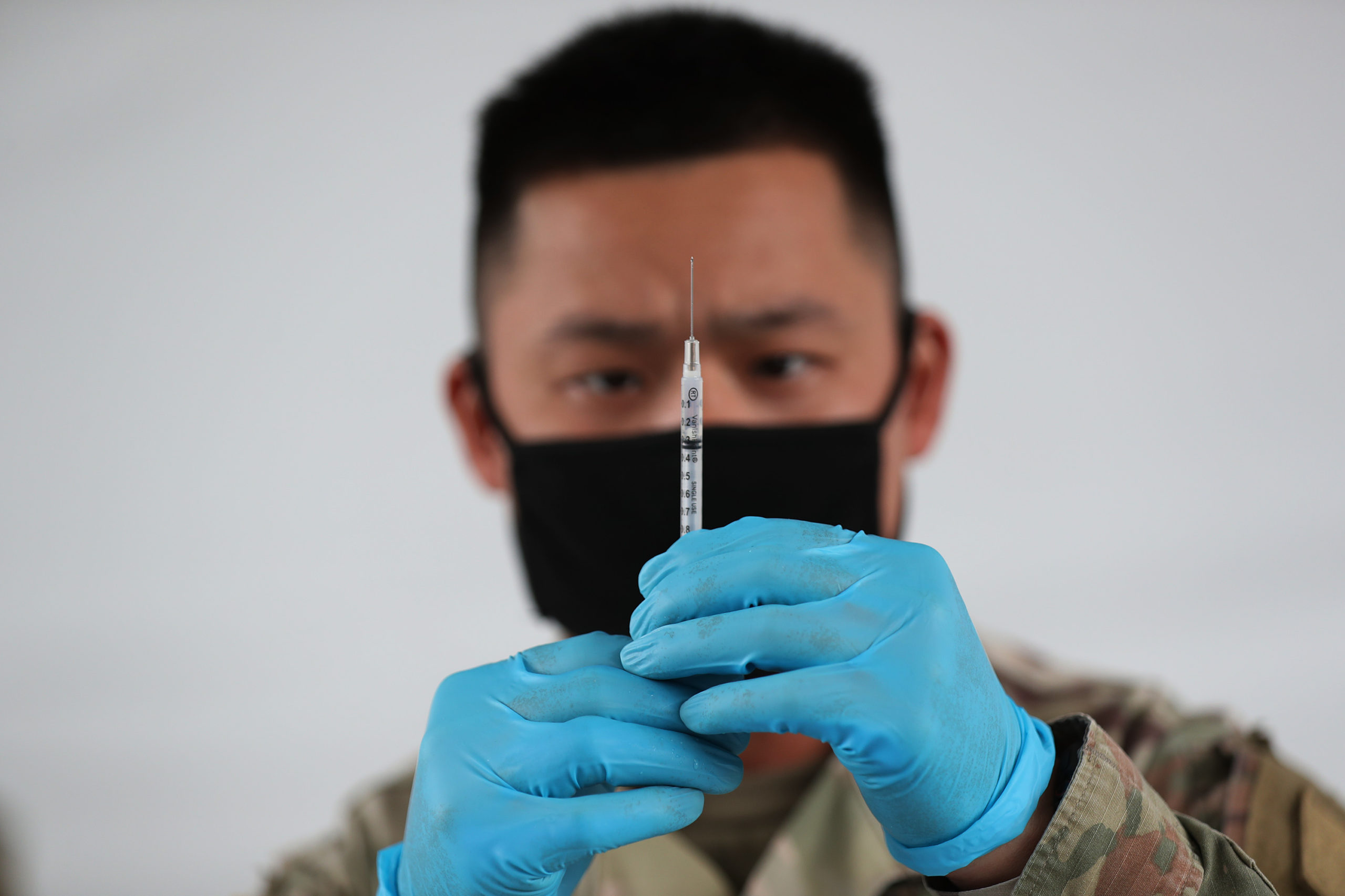 H 09: A U.S. Army soldier from the 2nd Armored Brigade Combat Team, 1st Infantry Division, prepares Pfizer COVID-19 vaccines to inoculate people at the Miami Dade College North Campus on March 09, 2021 in North Miami, Florida. The soldiers deployed to assist the Federal Emergency Management Agency at the state-run, federally-supported COVID-19 Community Vaccination Center. (Photo by Joe Raedle/Getty Images)