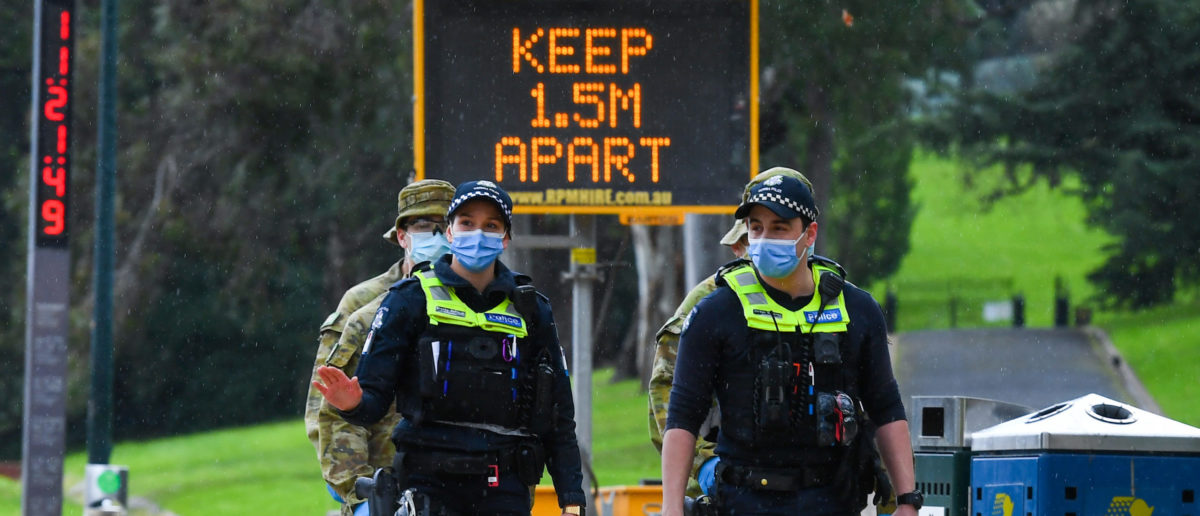 Police officers and soldiers patrol a popular running track in Melbourne on August 4, 2020 after the state announced new restrictions as the city battles fresh outbreaks of the COVID-19 coronavirus. - Melbourne is now enduring the country's most restrictive virus-control measures, including an overnight curfew, forced closure of non-essential businesses and mandatory mask-wearing as hundreds of new cases are recorded daily. (Photo by William WEST / AFP) (Photo by WILLIAM WEST/AFP via Getty Images)