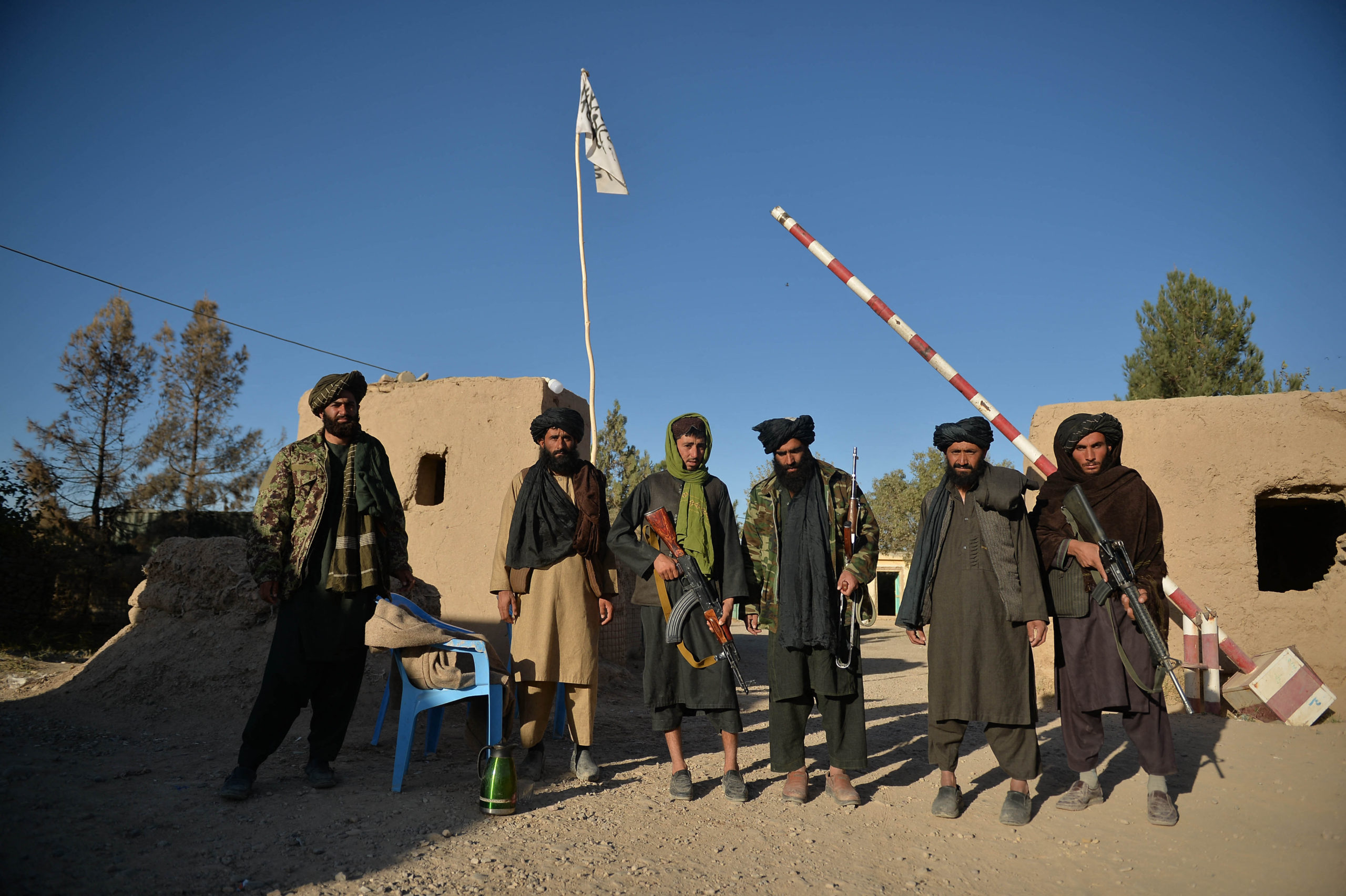 Taliban fighters stand guard at a police station gate in Ghasabha area in Qala-e-Now, Badghis province on October 14, 2021. (Photo by HOSHANG HASHIMI/AFP via Getty Images)