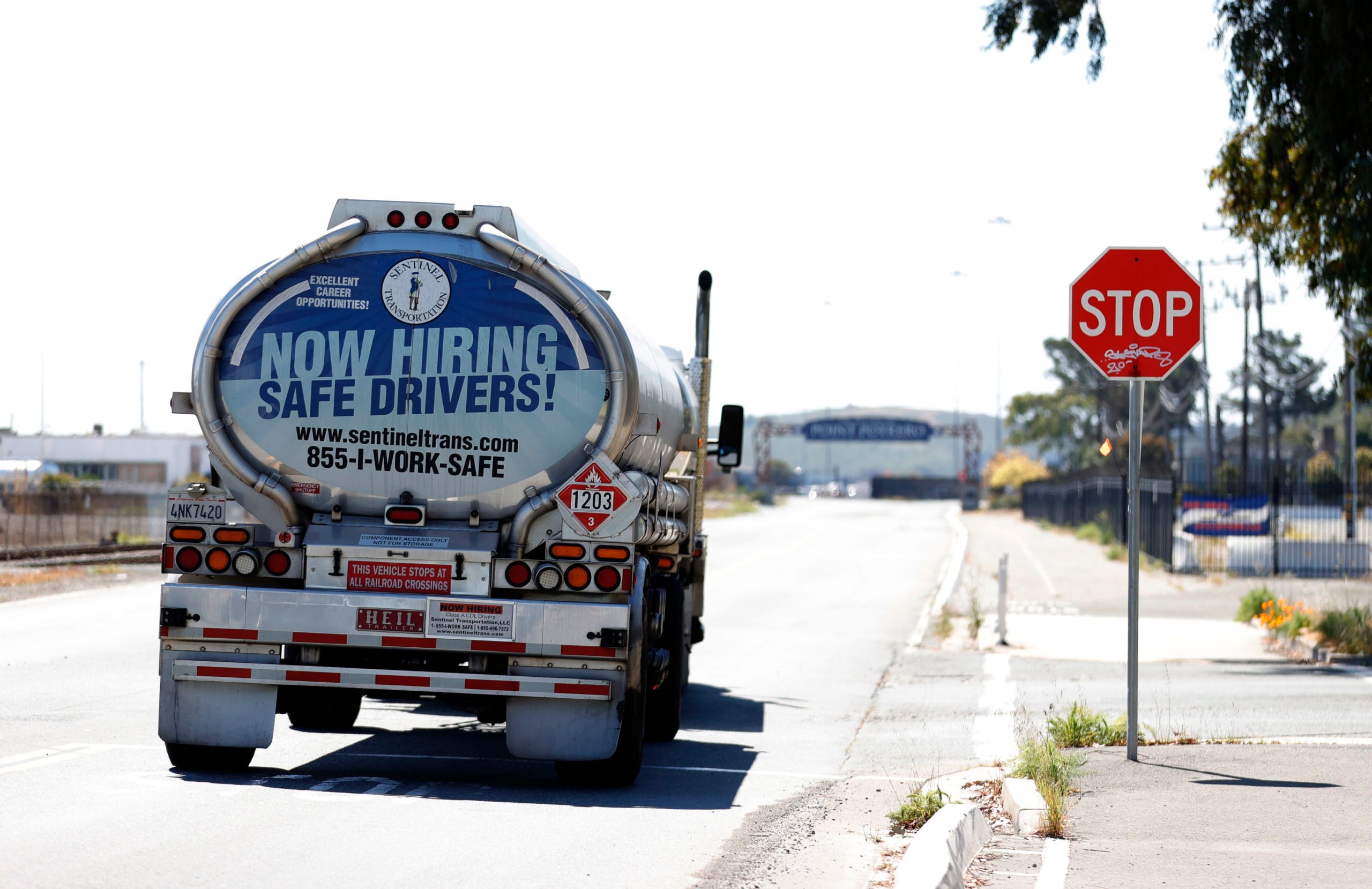 RICHMOND, CALIFORNIA - APRIL 29: A now hiring advertisement appears on the back of a fuel trucks on April 29, 2021 in Richmond, California. A lack of qualified truck drivers could lead to a shortage and gasoline this summer and could cause prices to spike. A gallon of regular unleaded gas is already at or around $4.00 in parts of California. (Photo by Justin Sullivan/Getty Images)
