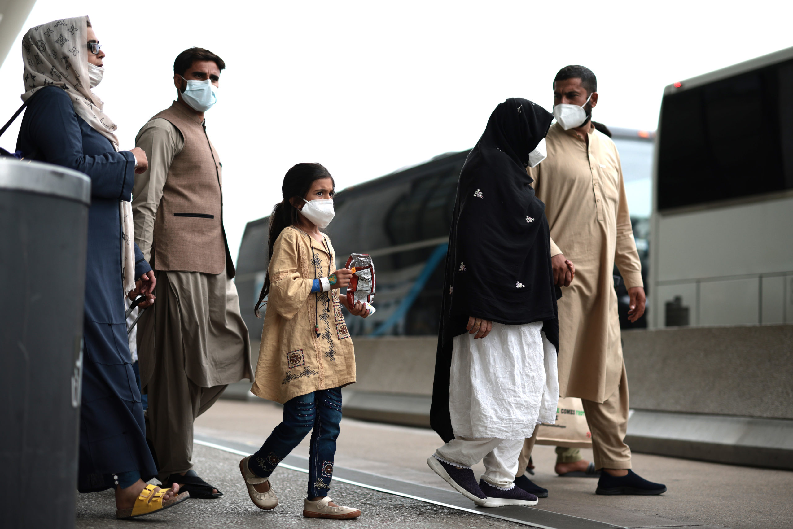  Refugees walk to board a bus at Dulles International Airport after being evacuated from Kabul following the Taliban takeover of Afghanistan on August 31, 2021 in Dulles, Virginia. (Photo by Anna Moneymaker/Getty Images)