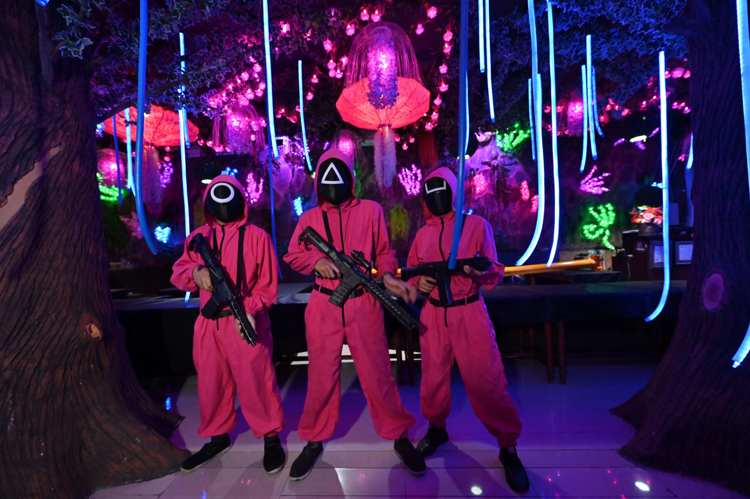 Waiters dressed in outfits from the Netflix series Squid Game pose while playing a game to attract customers at a cafe in Jakarta on October 19, 2021. (Photo by ADEK BERRY / AFP) (Photo by ADEK BERRY/AFP via Getty Images)