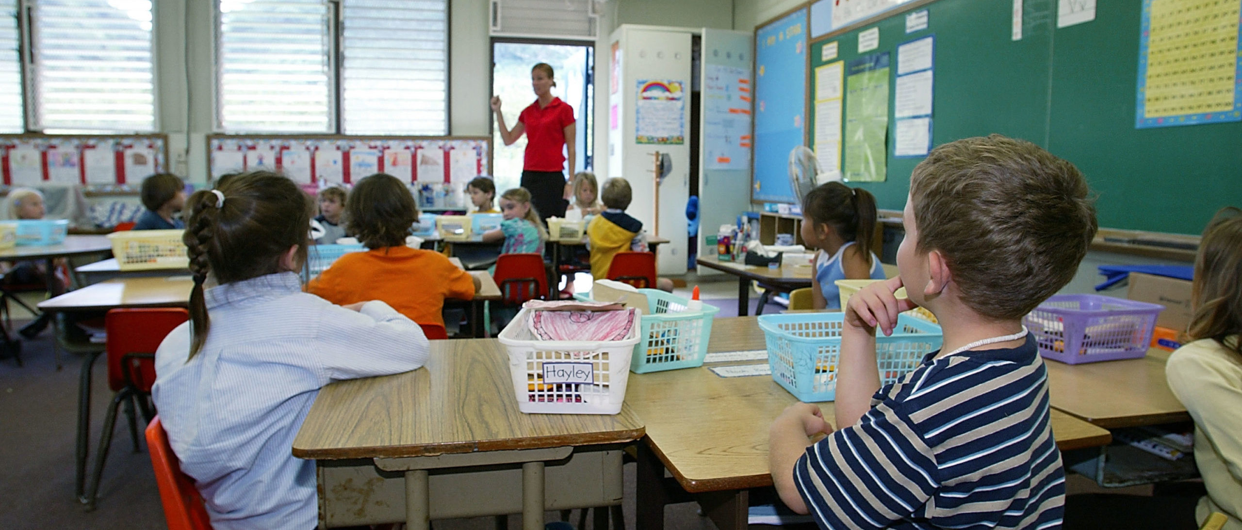 A kindergarten teacher prepares her students for a classroom lockdown drill February 18, 2003 in Oahu, Hawaii. Lockdown procedure is used to protect school children from possible threats on campus such as intruders, terrorism or military attack. (Photo by Phil Mislinski/Getty Images)