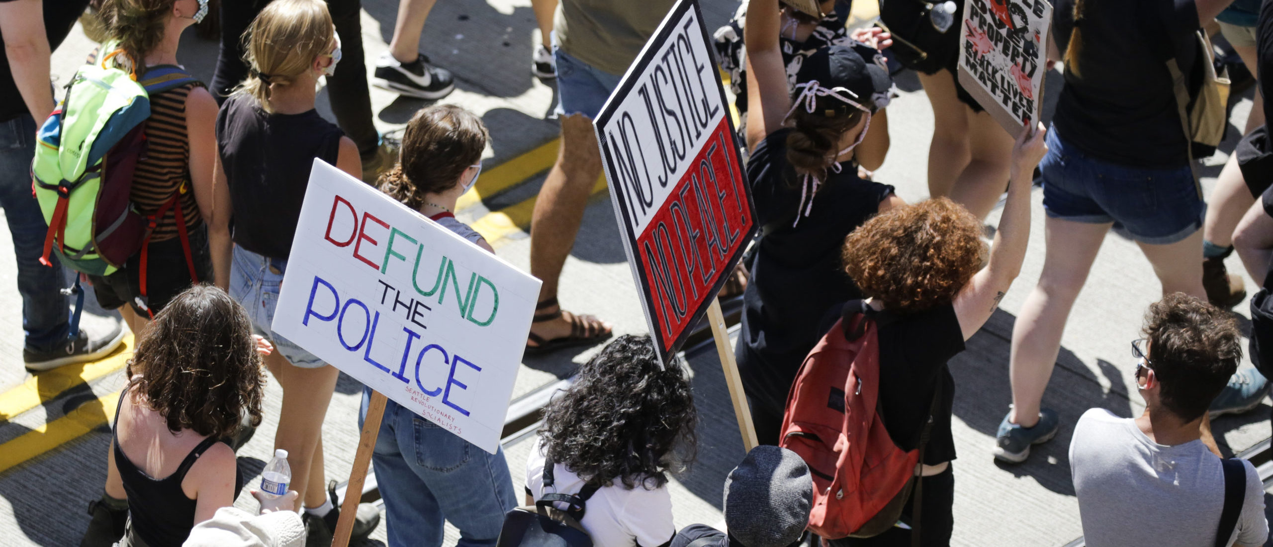 People carry signs during a "Defund the Police" march from King County Youth Jail to City Hall in Seattle, Washington on August 5, 2020. (Photo by Jason Redmond / AFP) (Photo by JASON REDMOND/AFP via Getty Images)