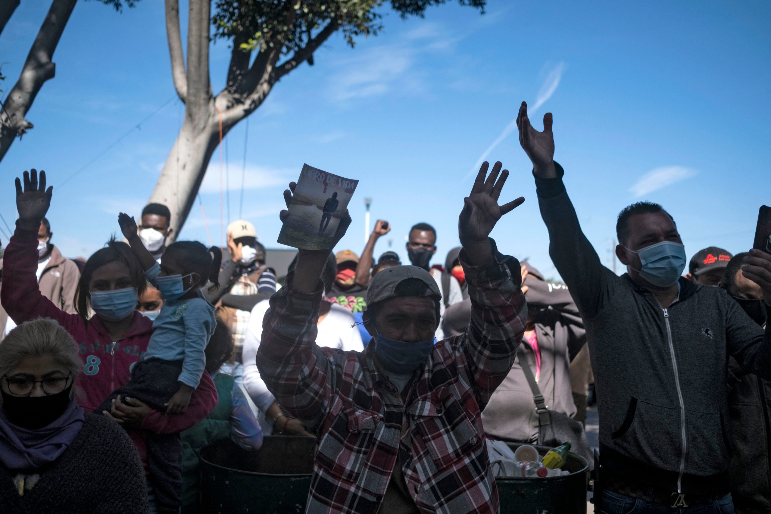 Migrants pray at camp where asylum seekers wait for US authorities to allow them to start their migration process outside El Chaparral crossing port in Tijuana, Baja California state, Mexico on March 17, 2021. (Photo by GUILLERMO ARIAS/AFP via Getty Images)