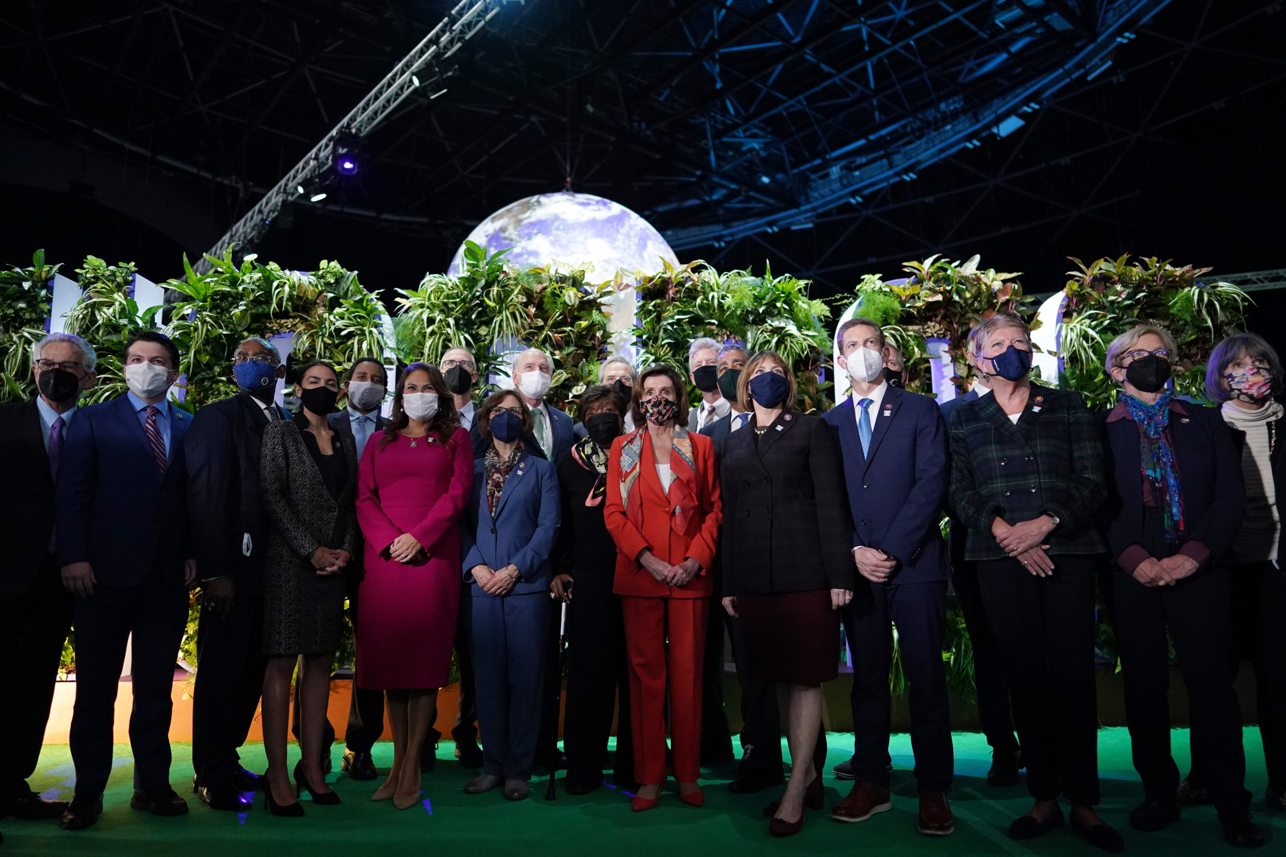 House Speaker Nancy Pelosi poses with the Democratic congressional delegation at COP26 on Tuesday in Glasgow, Scotland. (Ian Forsyth/Getty Images)