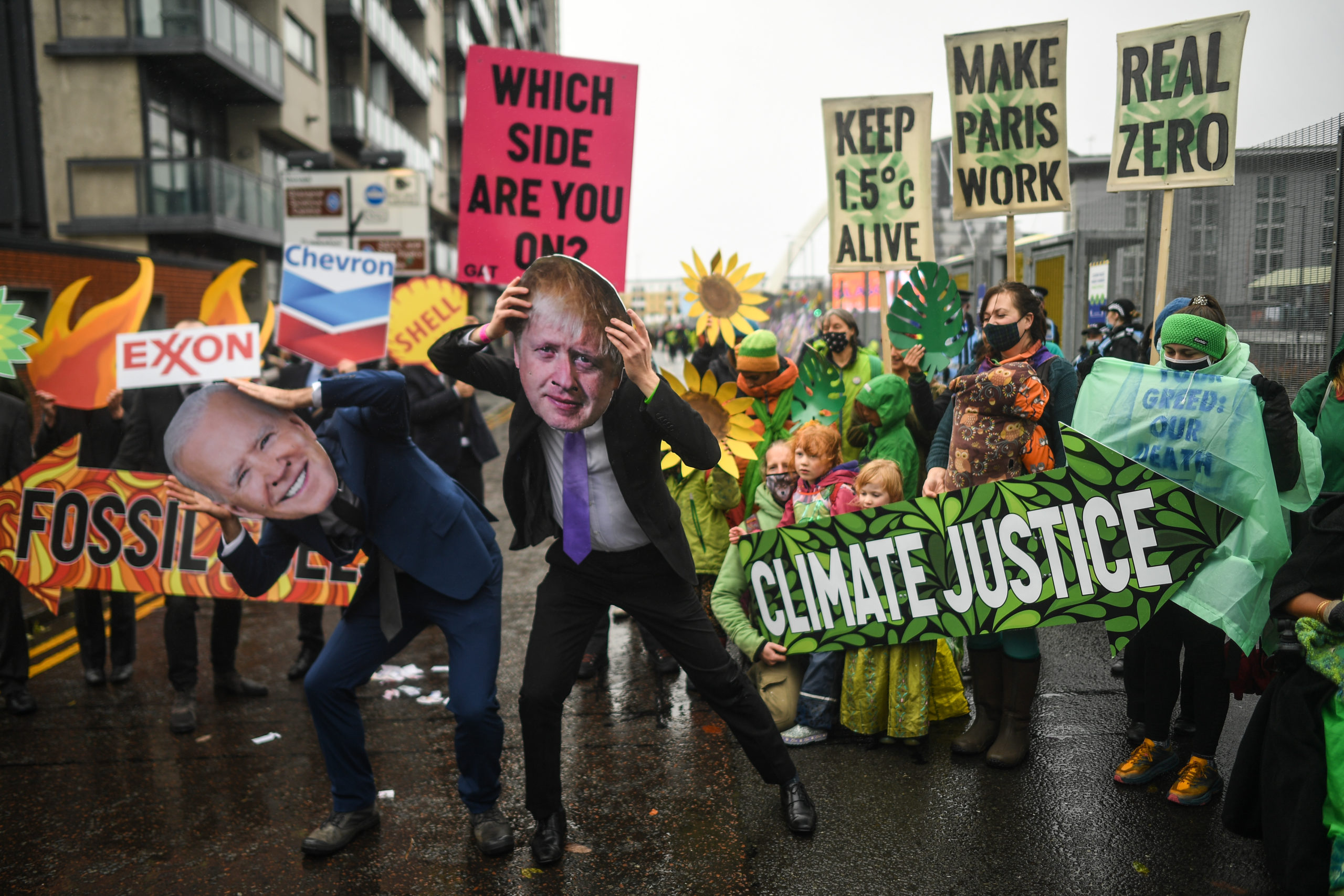 Protesters wearing masks of Boris Johnson and Joe Biden protest outside the entrance to the COP26 site on Friday. (Peter Summers/Getty Images)