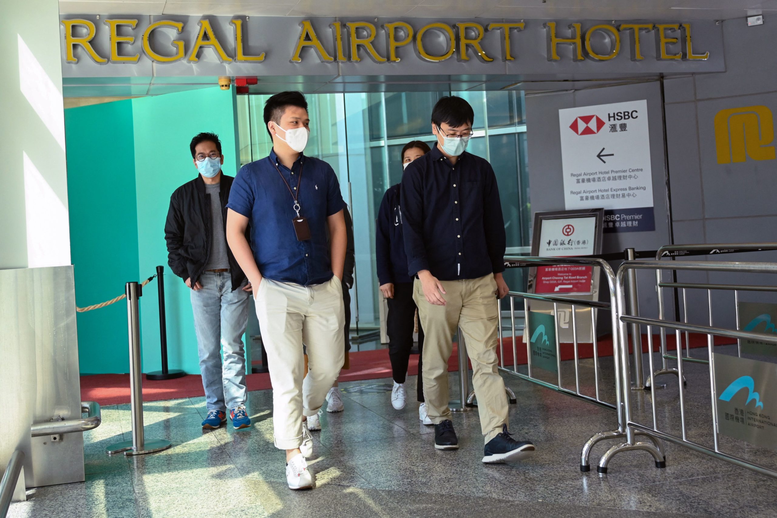 People leave the Regal Airport Hotel at Chek Lap Kok airport in Hong Kong on November 26, 2021, where a new Covid-19 variant deemed a 'major threat' was detected in a traveller from South Africa and who has since passed it on to a local man whilst in quarantine. (Photo by Peter PARKS / AFP) (Photo by PETER PARKS/AFP via Getty Images)