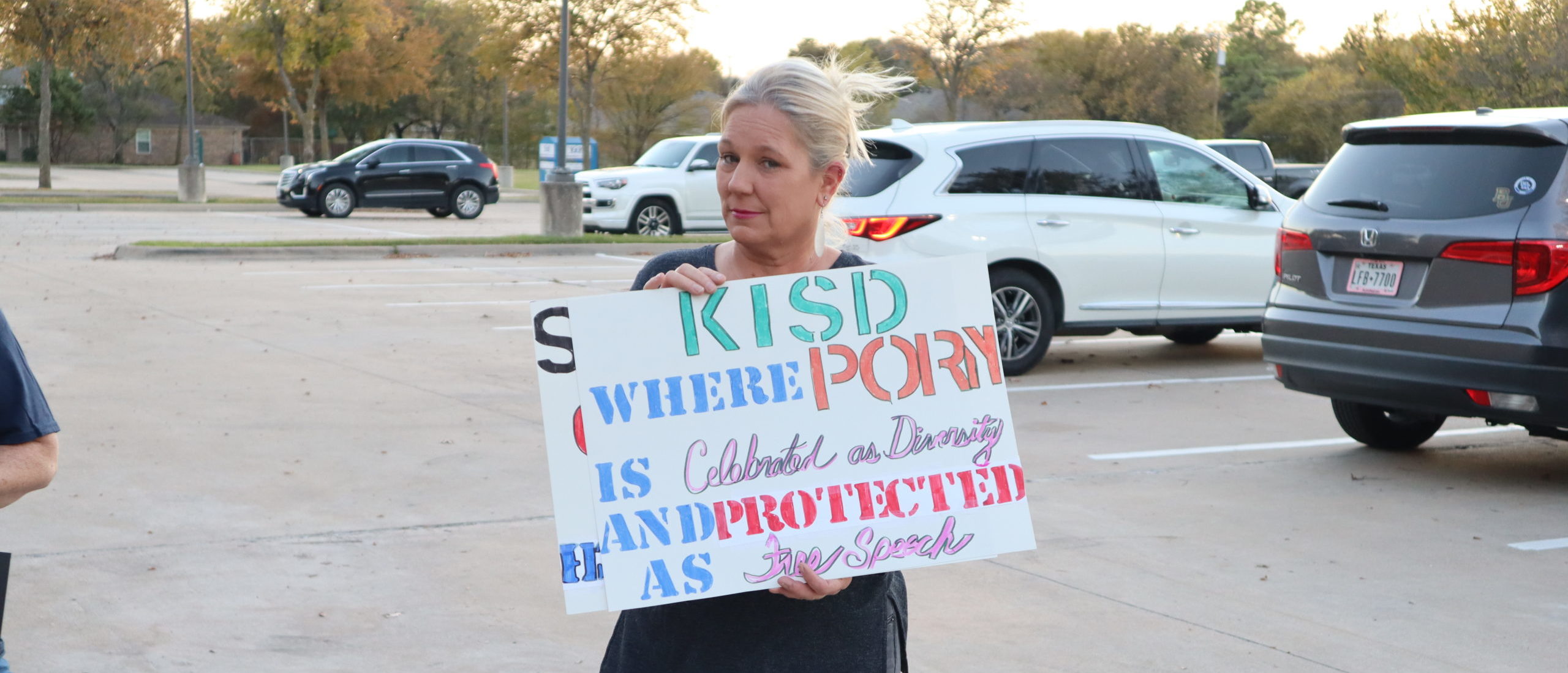Keller, TX -- A concerned mother holds a sign outside of a Keller Independent School District board meeting as parents protest the alleged inclusion of pornographic books in the district's libraries.