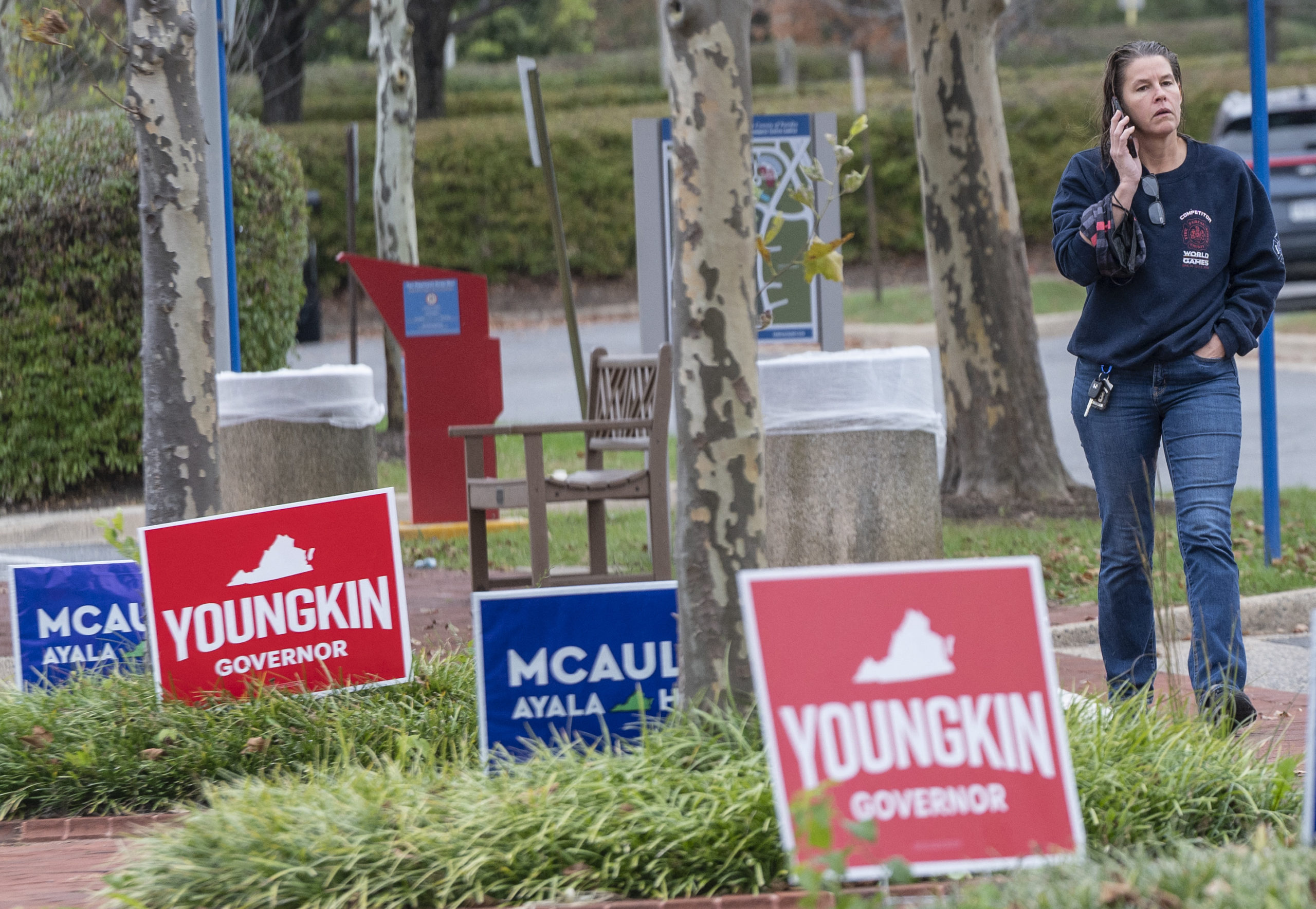 A voter walks past election signs as she walks to the Fairfax County Government Center polling location on election day in Fairfax, Virginia on November 2, 2021. (Photo by ANDREW CABALLERO-REYNOLDS/AFP via Getty Images)