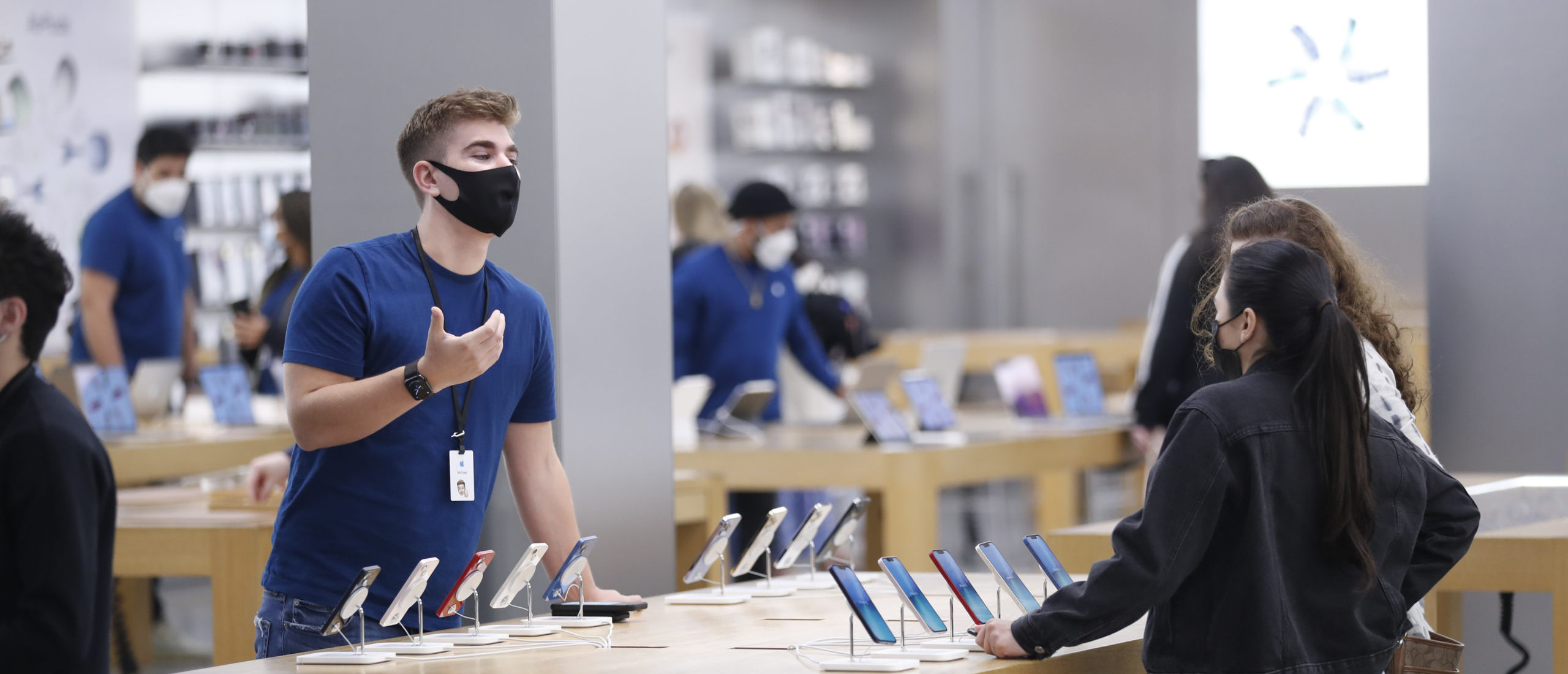 The Apple store employee helps customers during Black Friday at International Plaza on November 26, 2021 in Tampa, United States. (Photo by Octavio Jones/Getty Images)