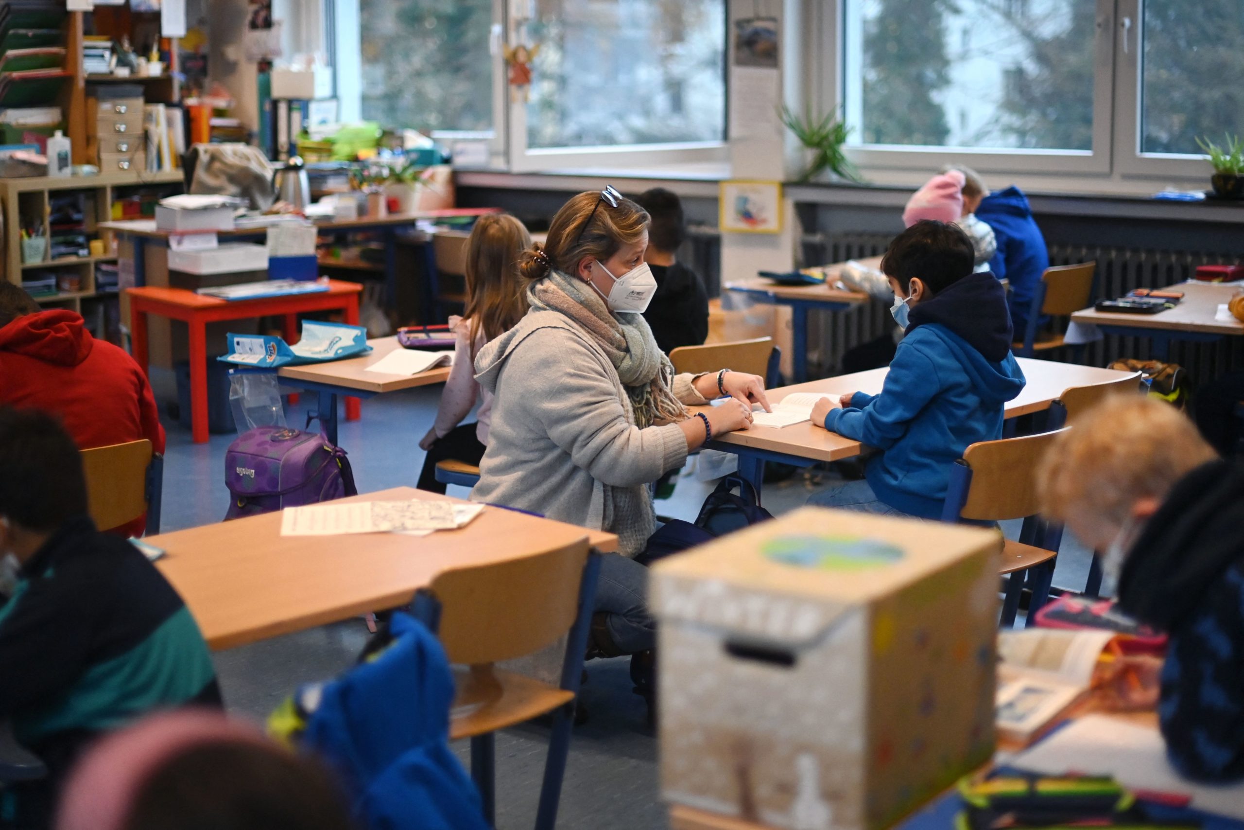 A teacher works with children of a school class during a lesson in their classroom at the Petri primary school in Dortmund, western Germany, on November 23, 2021 amid the novel coronavirus / COVID-19 pandemic. (Photo by INA FASSBENDER/AFP via Getty Images)