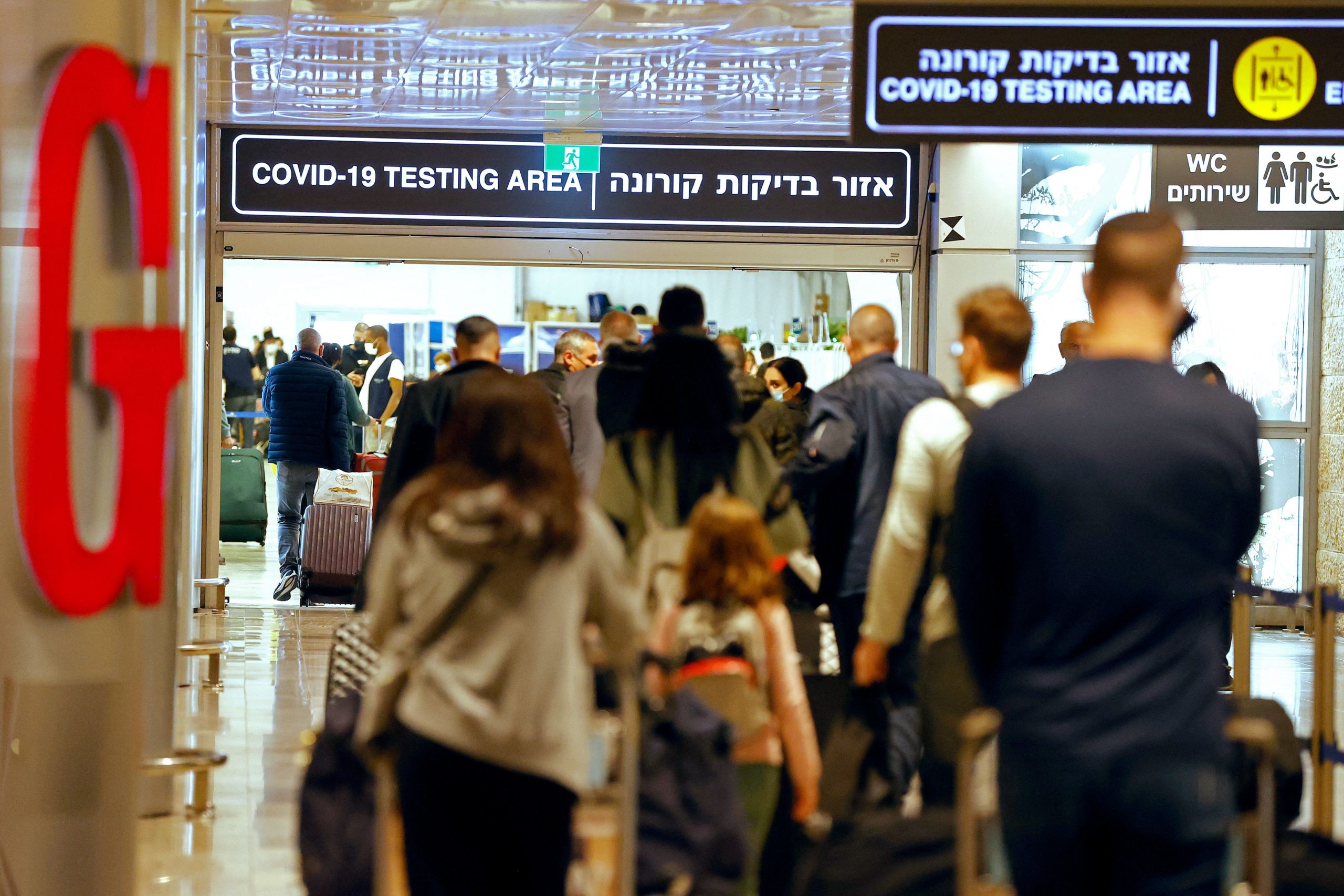 Passengers walk with their luggage upon their arrival at Ben Gurion Airport near Lod on November 1, 2021, as Israel reopens to tourists vaccinated against Covid-19. (JACK GUEZ/AFP via Getty Images)
