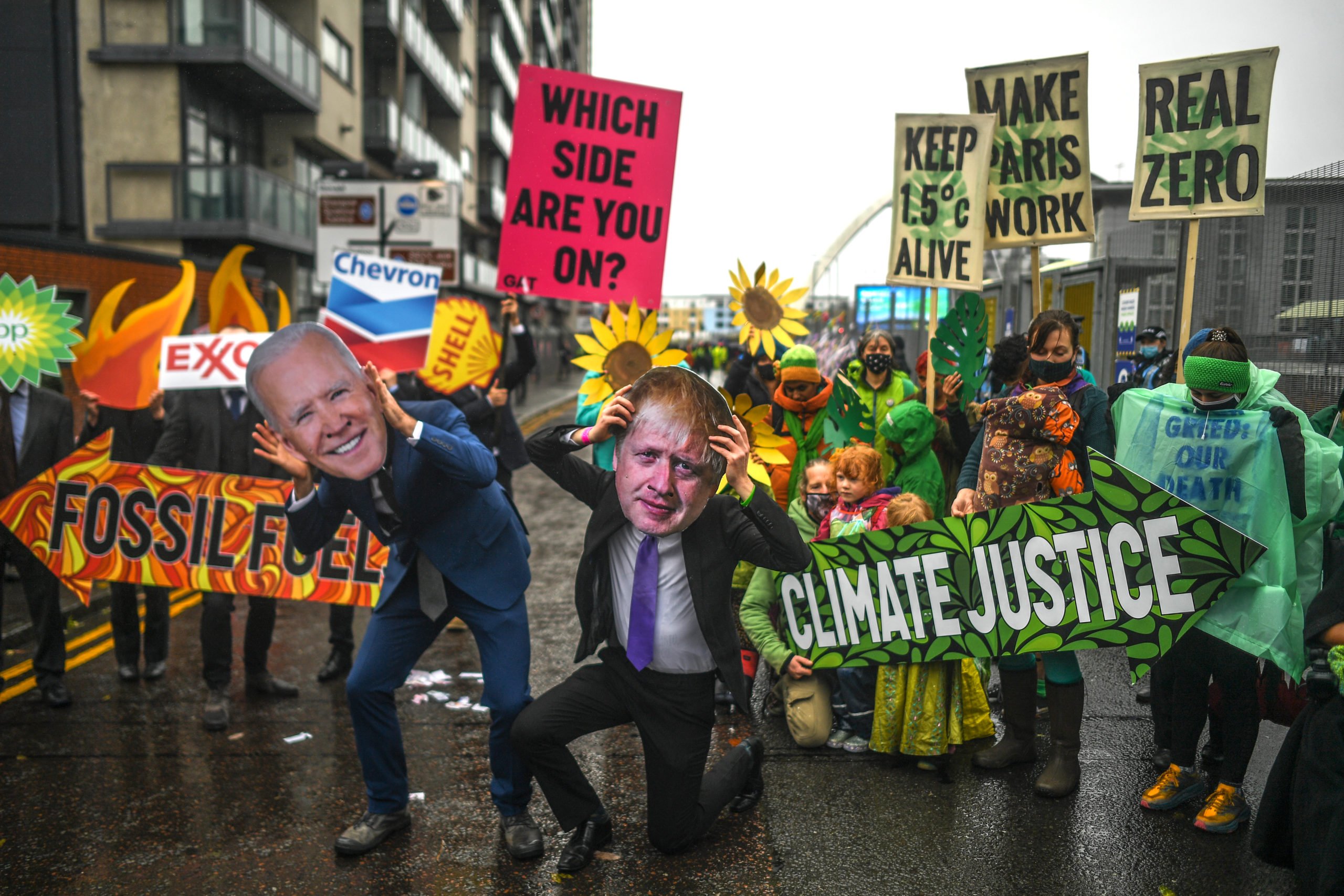 Protesters wearing masks of Boris Johnson and Joe Biden protest outside the entrance to the COP26 conference on Nov. 12 in Glasgow, United Kingdom. (Peter Summers/Getty Images)