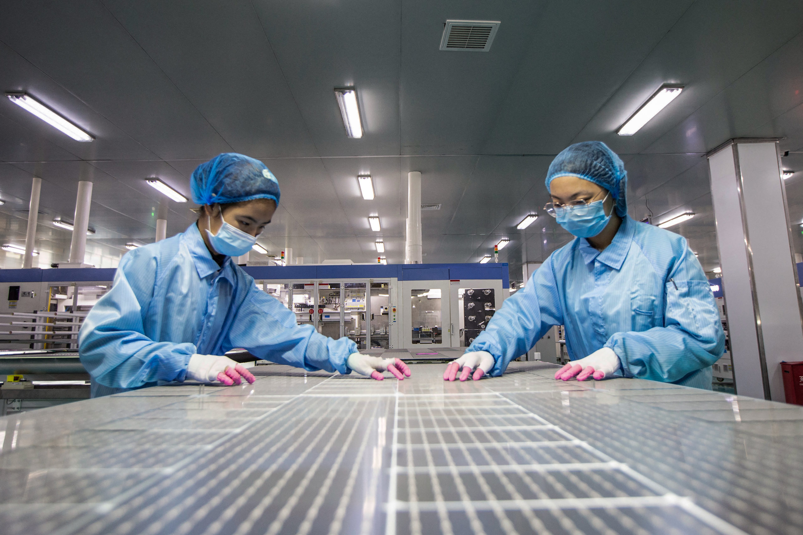 Employees work on solar modules at a factory in Haian in China's eastern Jiangsu province on Nov. 15. (STR/AFP via Getty Images)