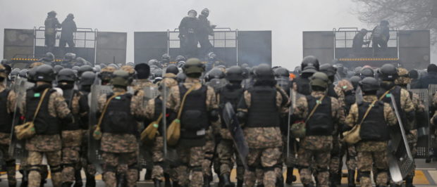 Kazakh law enforcement officers are seen on a barricade during a protest triggered by fuel price increase in Almaty, Kazakhstan January 5, 2022. REUTERS/Pavel Mikheyev