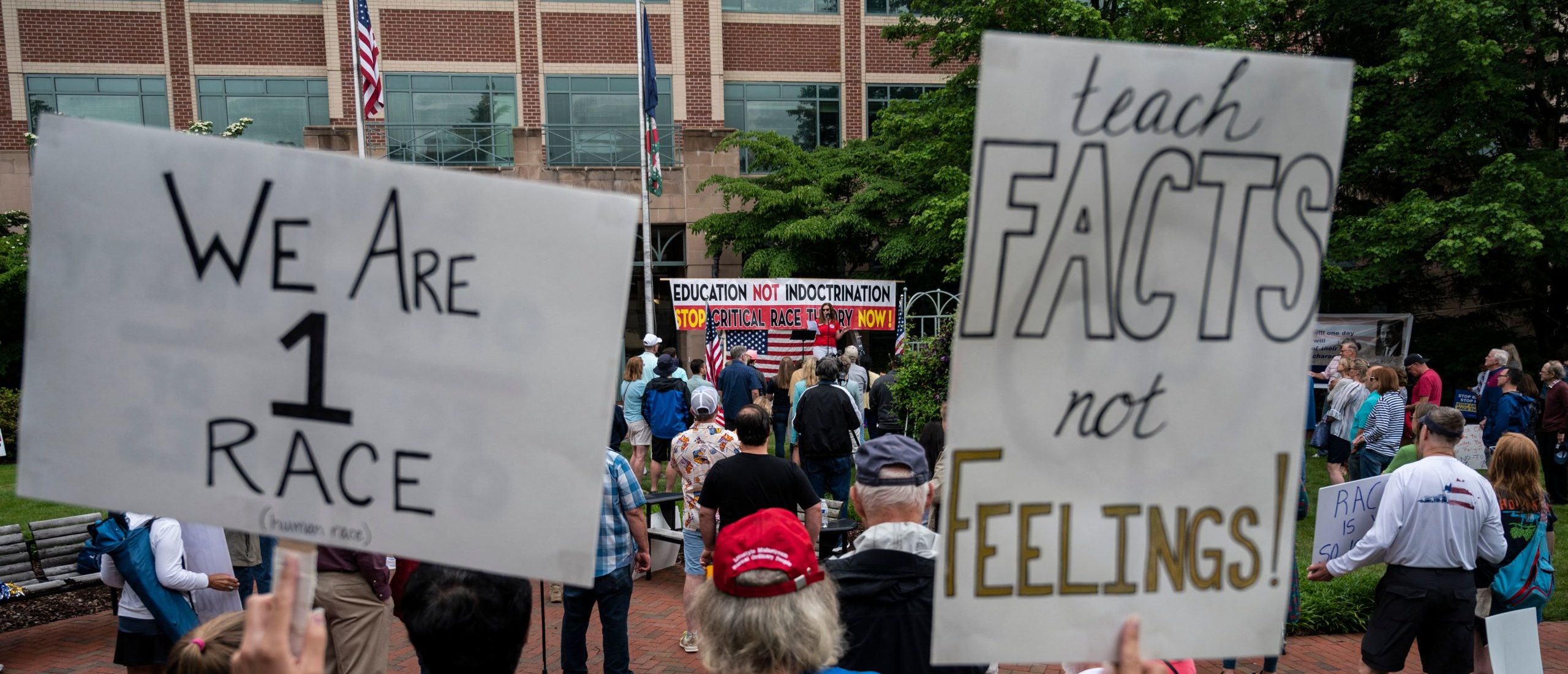 People hold up signs during a rally against "critical race theory" (CRT) being taught in schools at the Loudoun County Government center in Leesburg, Virginia on June 12, 2021. (Photo by ANDREW CABALLERO-REYNOLDS/AFP via Getty Images)