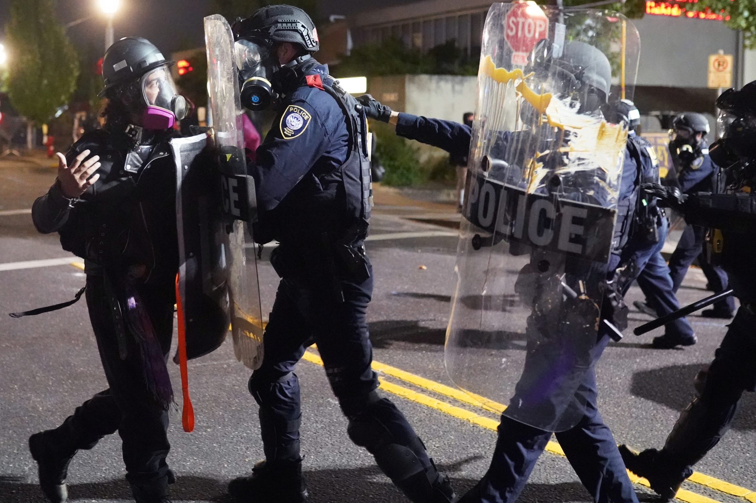 PORTLAND, OR - AUGUST 20: Federal officers use riot shields to push a protester while dispersing a crowd of about 150 people from in front of the Immigration and Customs Enforcement (ICE) detention facility on August 20, 2020 in Portland, Oregon. For the second night in a row federal police clashed with crowds in South Waterfront after being absent from Portlands nightly protest for weeks. (Photo by Nathan Howard/Getty Images)