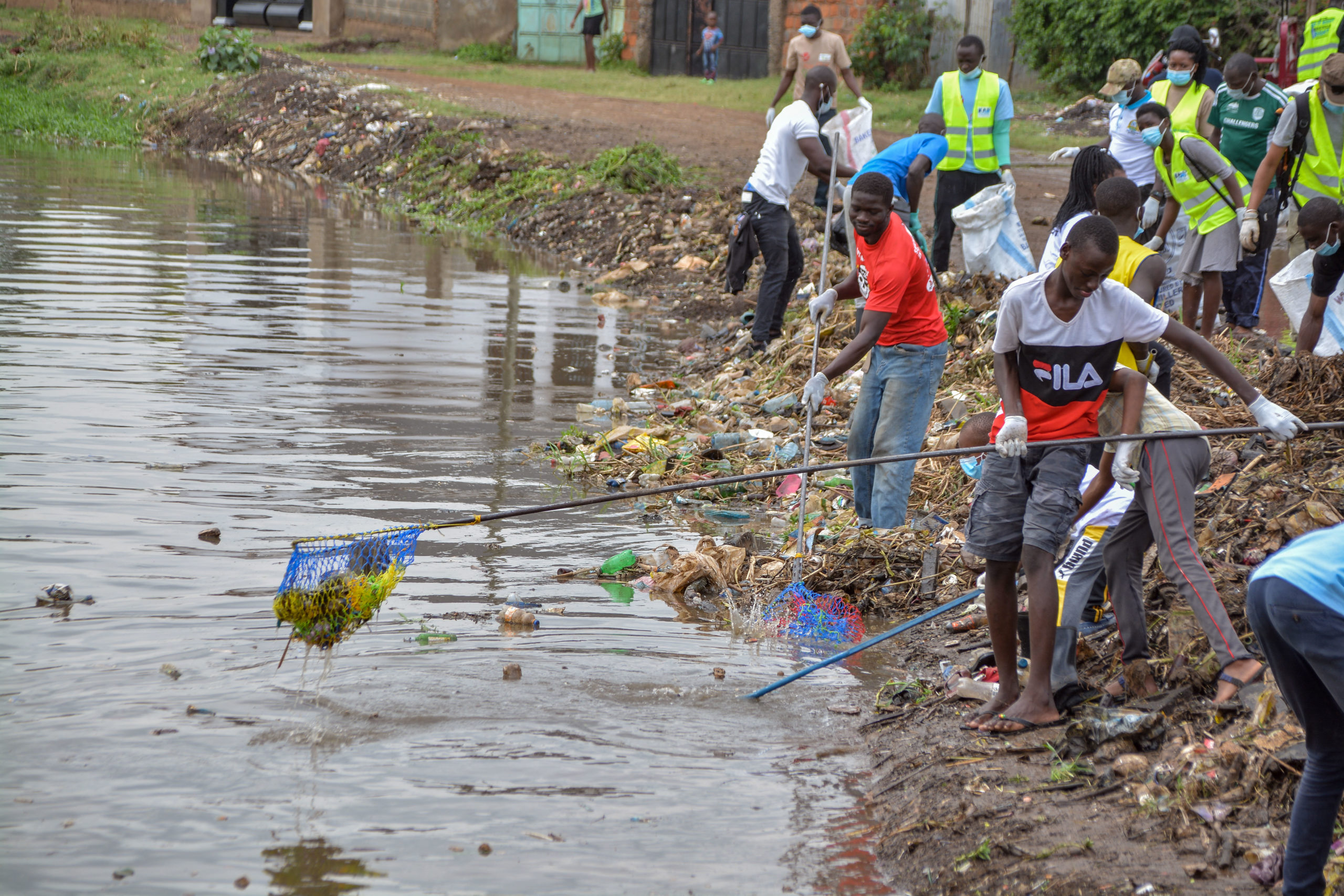 Community volunteers remove plastics with fishing net in Kisumu, Kenya to mark the World Cleanup Day, on Sept. 18. (Brian Ongoro/AFP via Getty Images)
