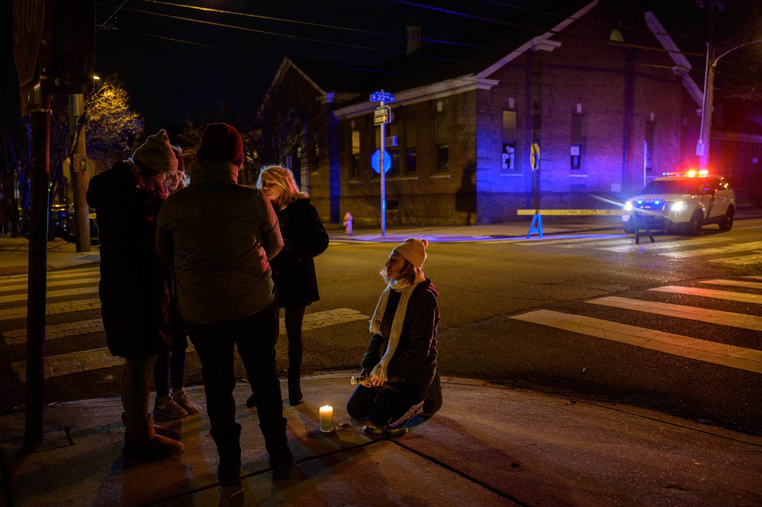 People hold a candlelight vigil near the scene of a deadly fire on January 5, 2022, in Philadelphia's popular museum district of Fairmount. (Photo by ED JONES/AFP via Getty Images)