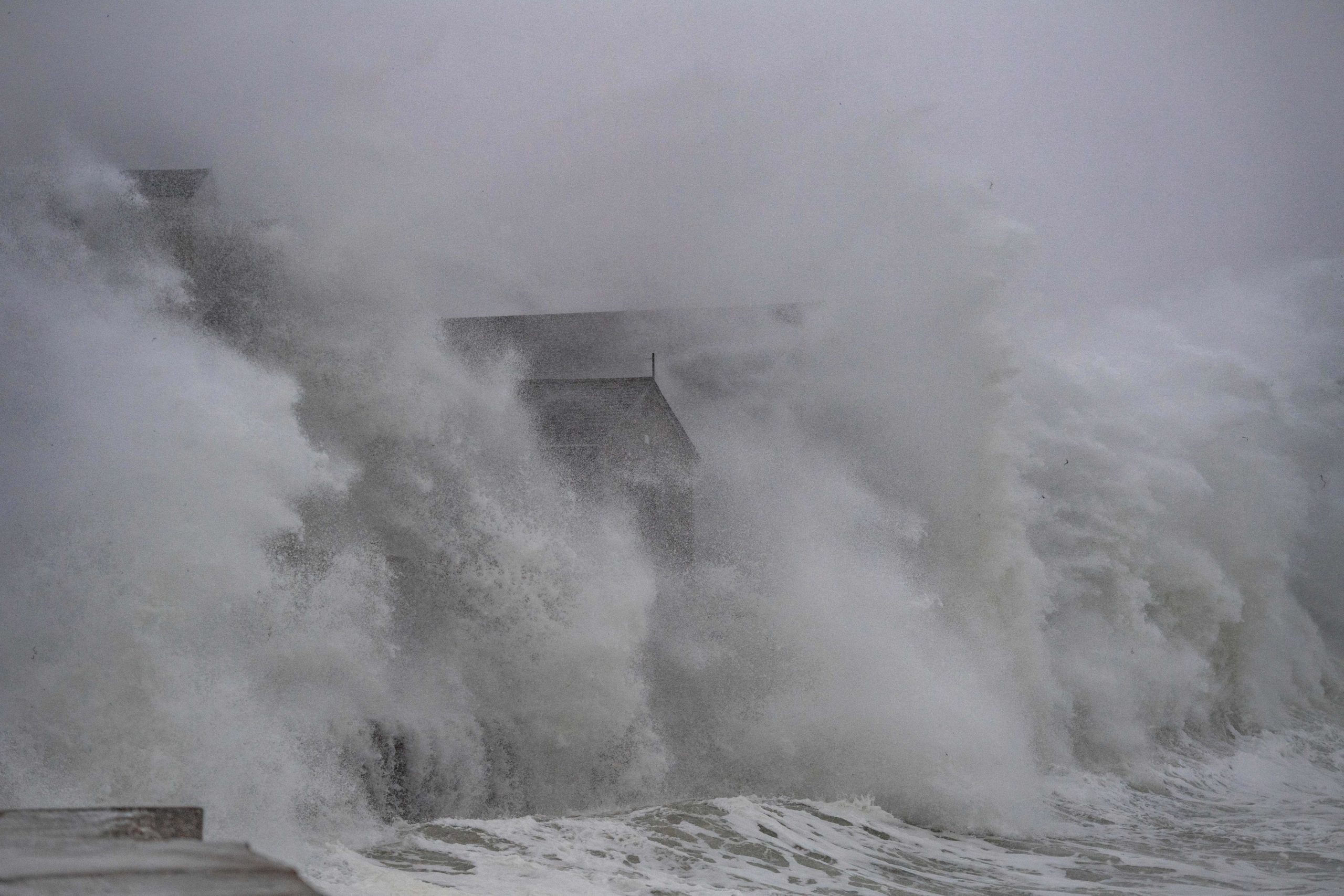 Waves crash over oceanfront homes during a noreaster in Scituate, Massachusetts, on January 29, 2022. - Blinding snow whipped up by near-hurricane force winds pummeled the eastern United States on January 29, as one of the strongest winter storms in years triggered severe weather alerts, transport chaos and power outages across a region of some 70 million people. (Photo by JOSEPH PREZIOSO / AFP) (Photo by JOSEPH PREZIOSO/AFP via Getty Images)