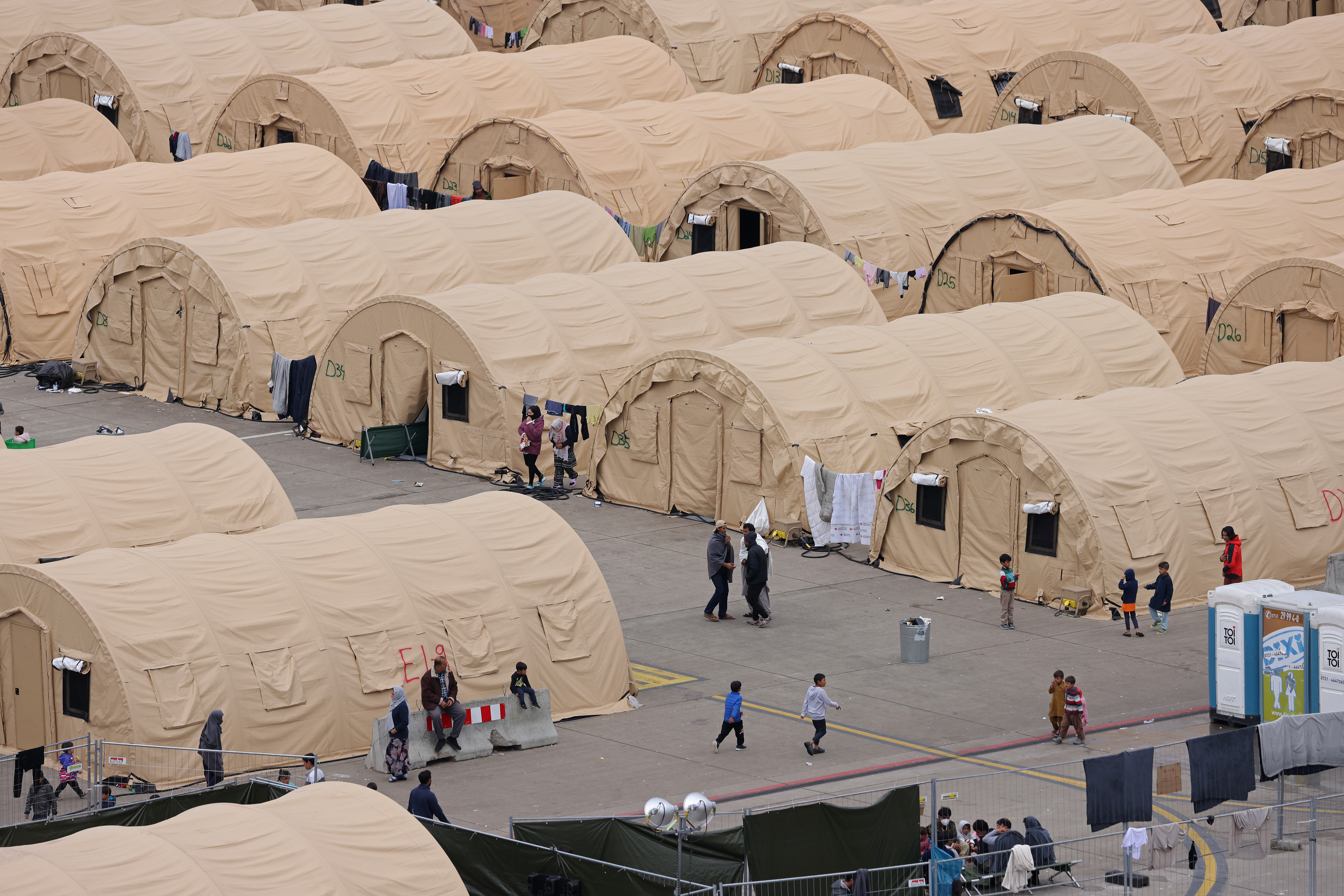 RAMSTEIN-MIESENBACH, GERMANY - SEPTEMBER 20: Children and adults while away time at a tent city of temporary accommodation built by the United States Air Force for evacuees from Afghanistan at Ramstein Air Base on September 20, 2021 in Ramstein-Miesenbach, Germany. Approximately 6,000 evacuees are currently at the base, with approximately another 3,000 at nearby U.S. Rhine Ordinance Barracks. Medical personnel administered a first round of vaccinations against Covid-19 to the evacuees over the last few days, which means no evacuees will be able to journey onward to the United States for at least two weeks until they get their second inoculation. So far approximately 34,000 Afghan evacuees have passed through Ramstein on their way to resettlement in the U.S. (Photo by Sean Gallup/Getty Images)