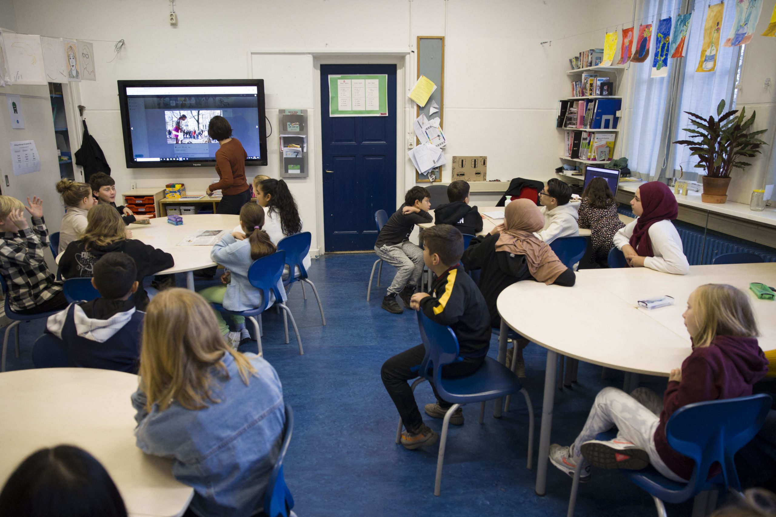 Pupils listen to their teacher in a classroom at the De La Reyschool, as the number of corona infections is rising, especially among children, in The Hague on November 19, 2021. - Dutch Prime Minister Mark Rutte announced one week ago Western Europe's first partial lockdown of the winter, with at least three weeks of Covid curbs on restaurants, shops and sporting events. - Netherlands OUT (Photo by Arie KIEVIT / ANP / AFP) / Netherlands OUT (Photo by ARIE KIEVIT/ANP/AFP via Getty Images)