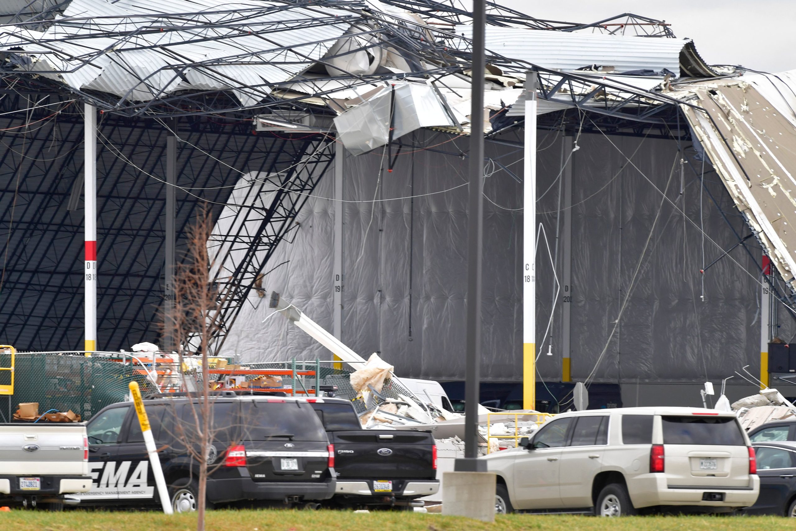 Workers remove debris from an Amazon Fulfillment Center in Edwardsville, Illinois, on December 11, 2021, after it was hit by a tornado. - Tornadoes ripped through five US states overnight, leaving more than 70 people dead Saturday in Kentucky and causing multiple fatalities at an Amazon warehouse in Illinois that suffered "catastrophic damage" with around 100 people trapped inside. The western Kentucky town of Mayfield was "ground zero" of the storm -- a scene of "massive devastation," one official said. (Photo by Tim Vizer / AFP) (Photo by TIM VIZER/AFP via Getty Images)