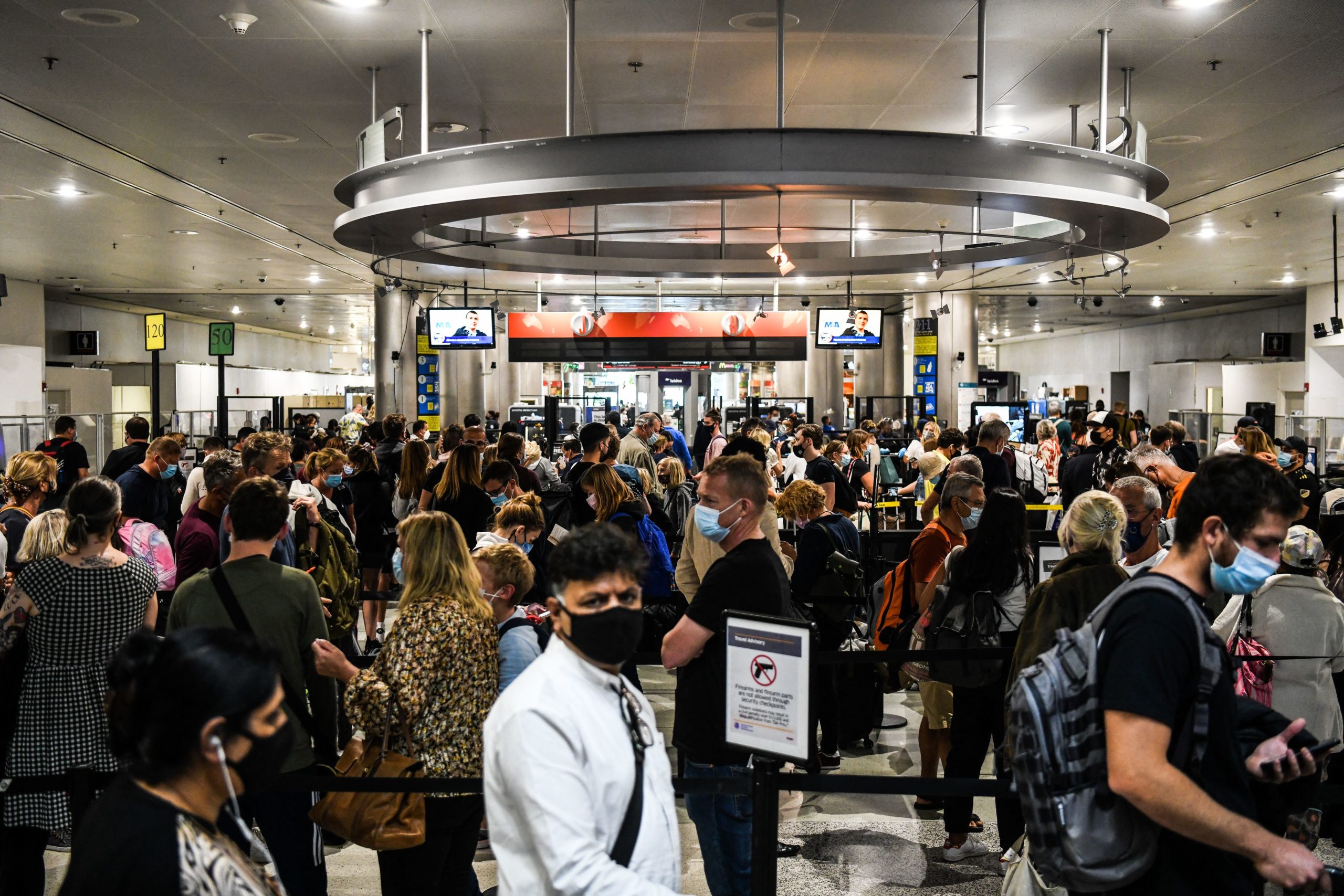 People wait for security check-in at the Miami International Airport in Miami, Florida on January 3, 2022. (Photo by CHANDAN KHANNA/AFP via Getty Images)