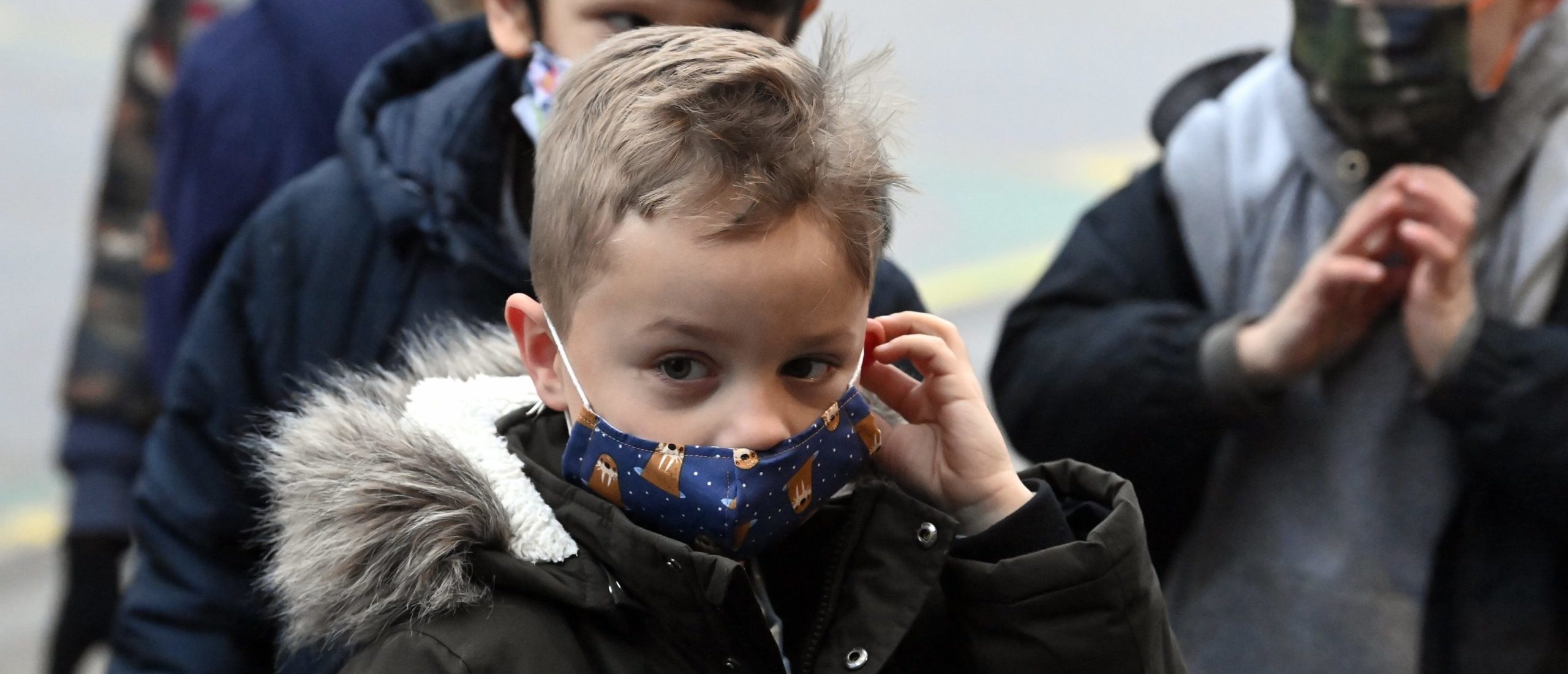 Children wear mouth masks on the playground of a primary school in Helecine, Monday 06 December 2021. (Photo by ERIC LALMAND/BELGA MAG/AFP via Getty Images)
