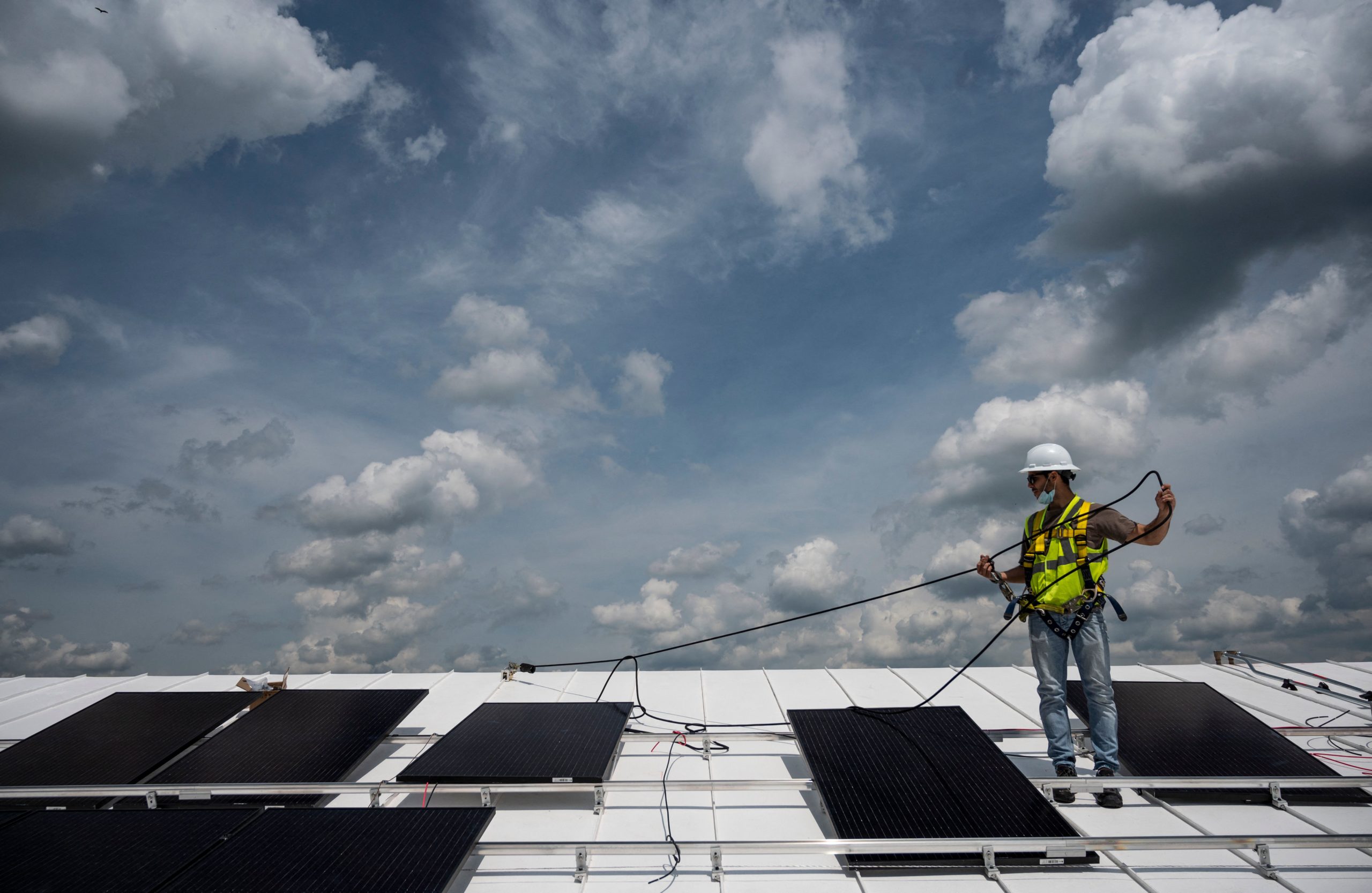 A worker installs solar panels on the roof of a church in Alexandria, Virginia on May 17. (Andrew Caballero-Reynolds/AFP via Getty Images)