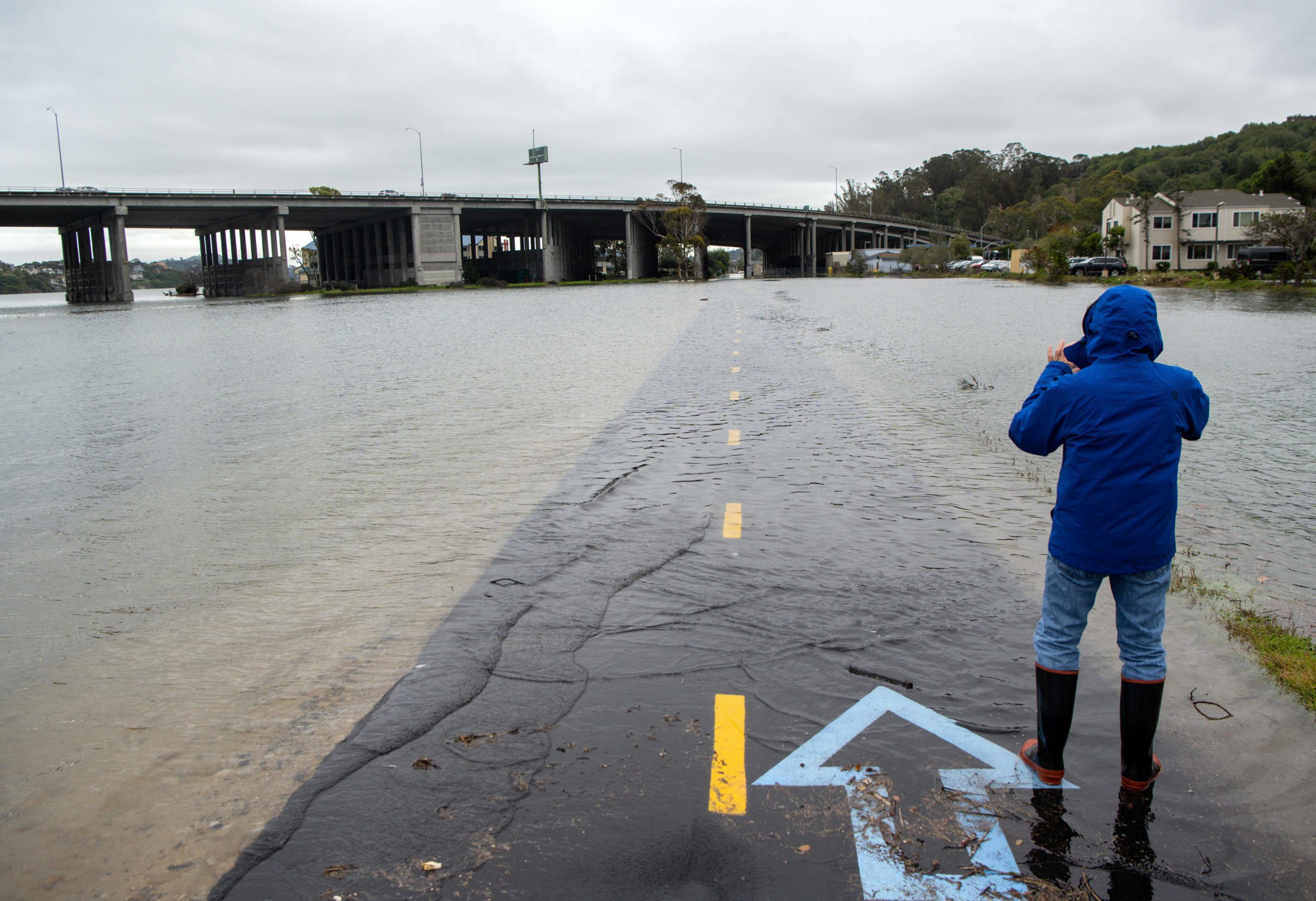A man takes a photo of a flooded bike path in Mill Valley, California, on Jan. 3. (Josh Edelson/AFP via Getty Images)