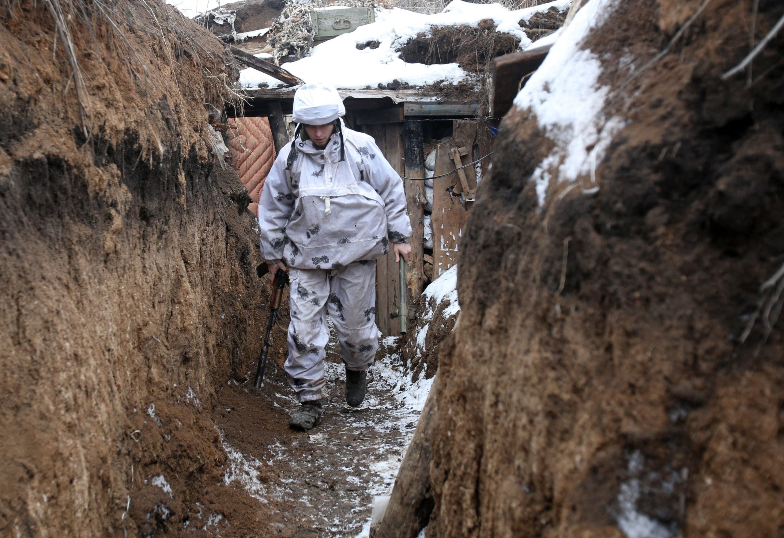 TOPSHOT - An Ukrainian serviceman walks along a snow covered trench on the frontline with the Russia-backed separatists near Verkhnetoretskoye village, in the Donetsk region on February 1, 2022. (Photo by Anatolii STEPANOV / AFP) (Photo by ANATOLII STEPANOV/AFP via Getty Images)