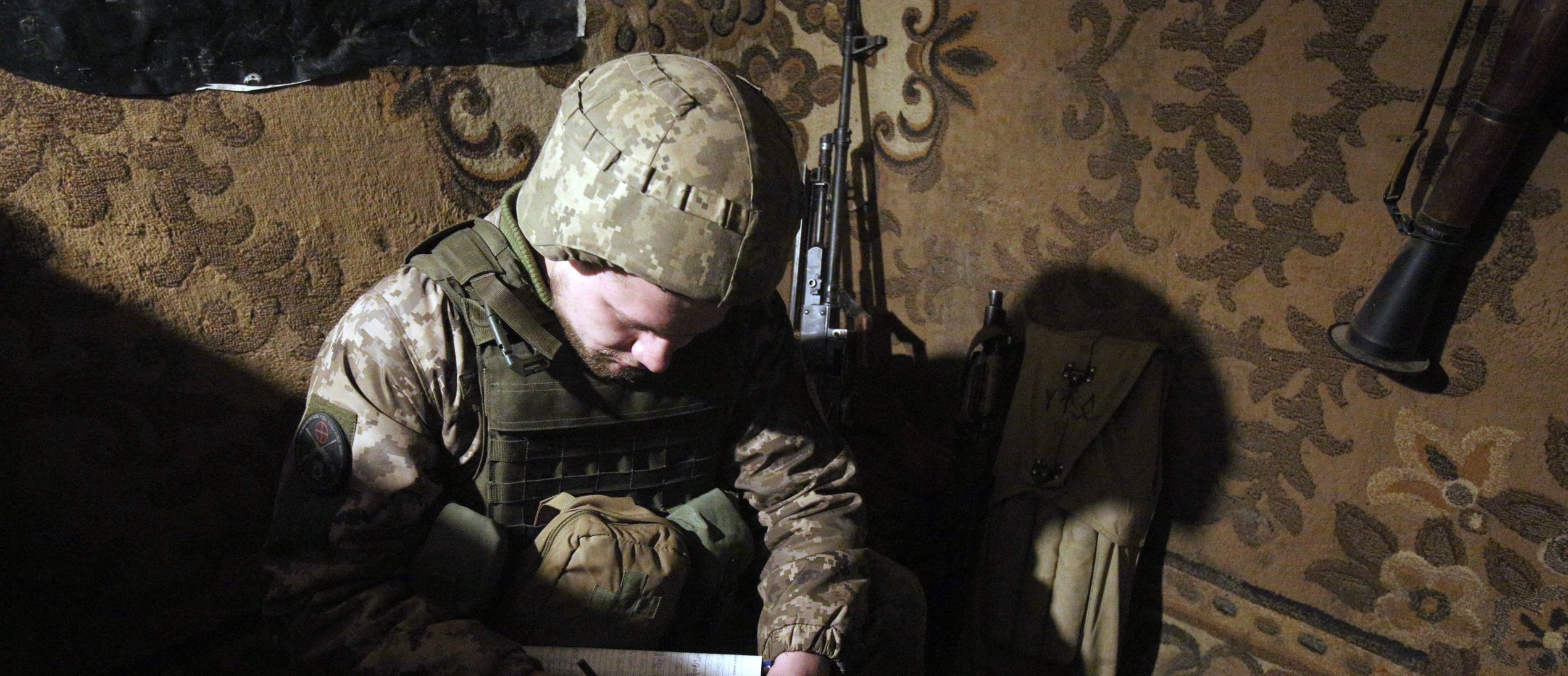 A serviceman of Ukrainian Military Forces writes notes as he keeps his position on the front line with Russia backed separatists, near Novolugansk, in the Donetsk region, on February 17, 2022. (Photo by Anatolii STEPANOV / AFP) (Photo by ANATOLII STEPANOV/AFP via Getty Images)