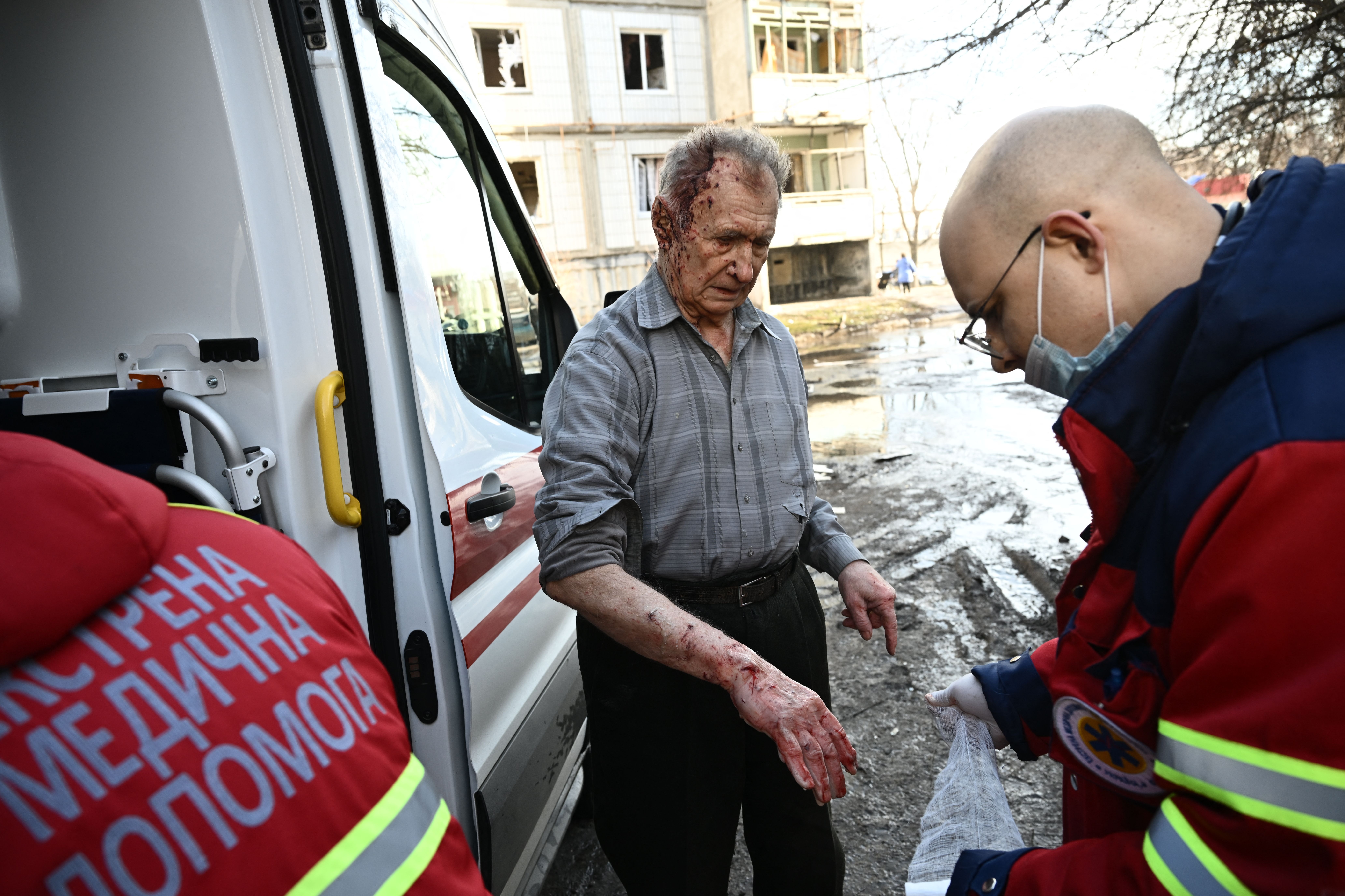 Emergency unit staff treat an injured man after bombings on the eastern Ukraine town of Chuguiv on February 24, 2022, as Russian armed forces are trying to invade Ukraine from several directions, using rocket systems and helicopters to attack Ukrainian position in the south, the border guard service said. - Russia's ground forces today crossed into Ukraine from several directions, Ukraine's border guard service said, hours after President Vladimir Putin announced the launch of a major offensive. Russian tanks and other heavy equipment crossed the frontier in several northern regions, as well as from the Kremlin-annexed peninsula of Crimea in the south, the agency said. (Photo by ARIS MESSINIS/AFP via Getty Images)