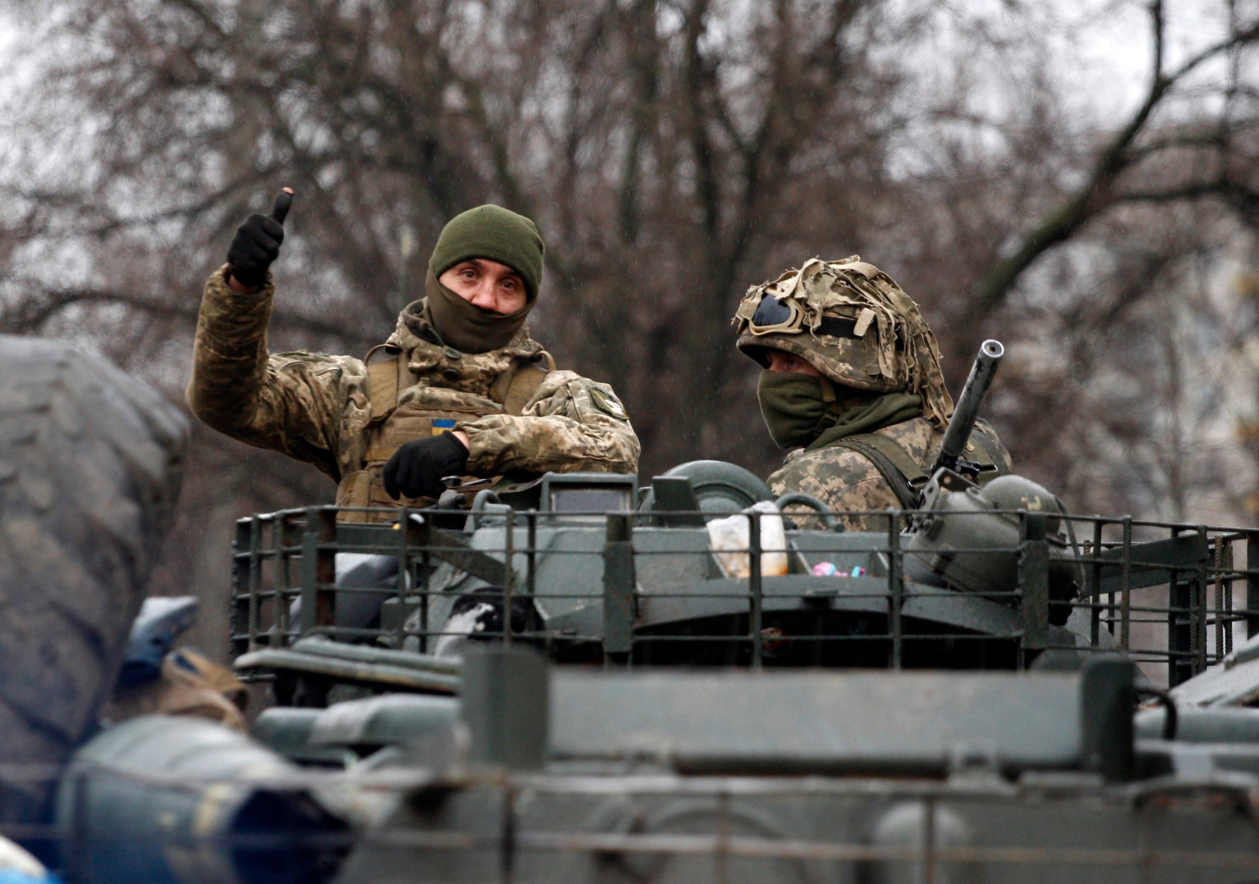 A Ukrainian serviceman gives a thumb up riding atop a military vehicle before an attack in Lugansk region on February 26, 2022. - Russia on February 26 ordered its troops to advance in Ukraine "from all directions" as the Ukrainian capital Kyiv imposed a blanket curfew and officials reported 198 civilian deaths. (Photo by Anatolii Stepanov / AFP) (Photo by ANATOLII STEPANOV/AFP via Getty Images)