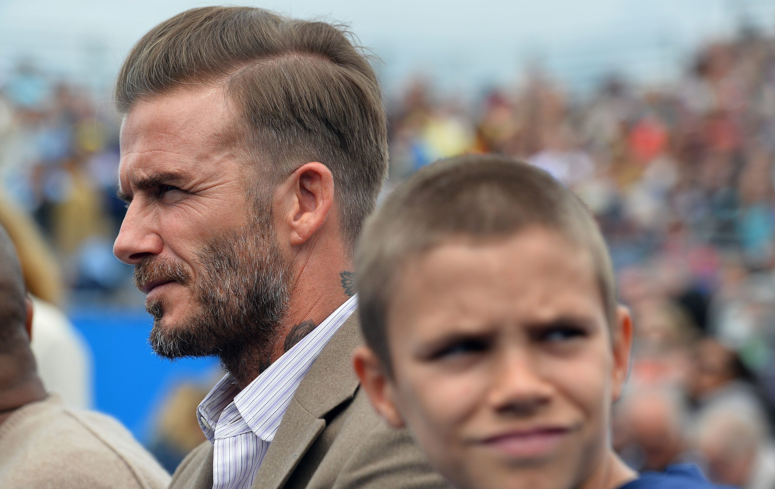 Former English footballer David Beckham and his son Romeo watch the play on centre court at the ATP Aegon Championships tennis tournament at the Queen's Club in west London on June 14, 2016. / AFP PHOTO / GLYN KIRK (Photo credit should read GLYN KIRK/AFP via Getty Images)