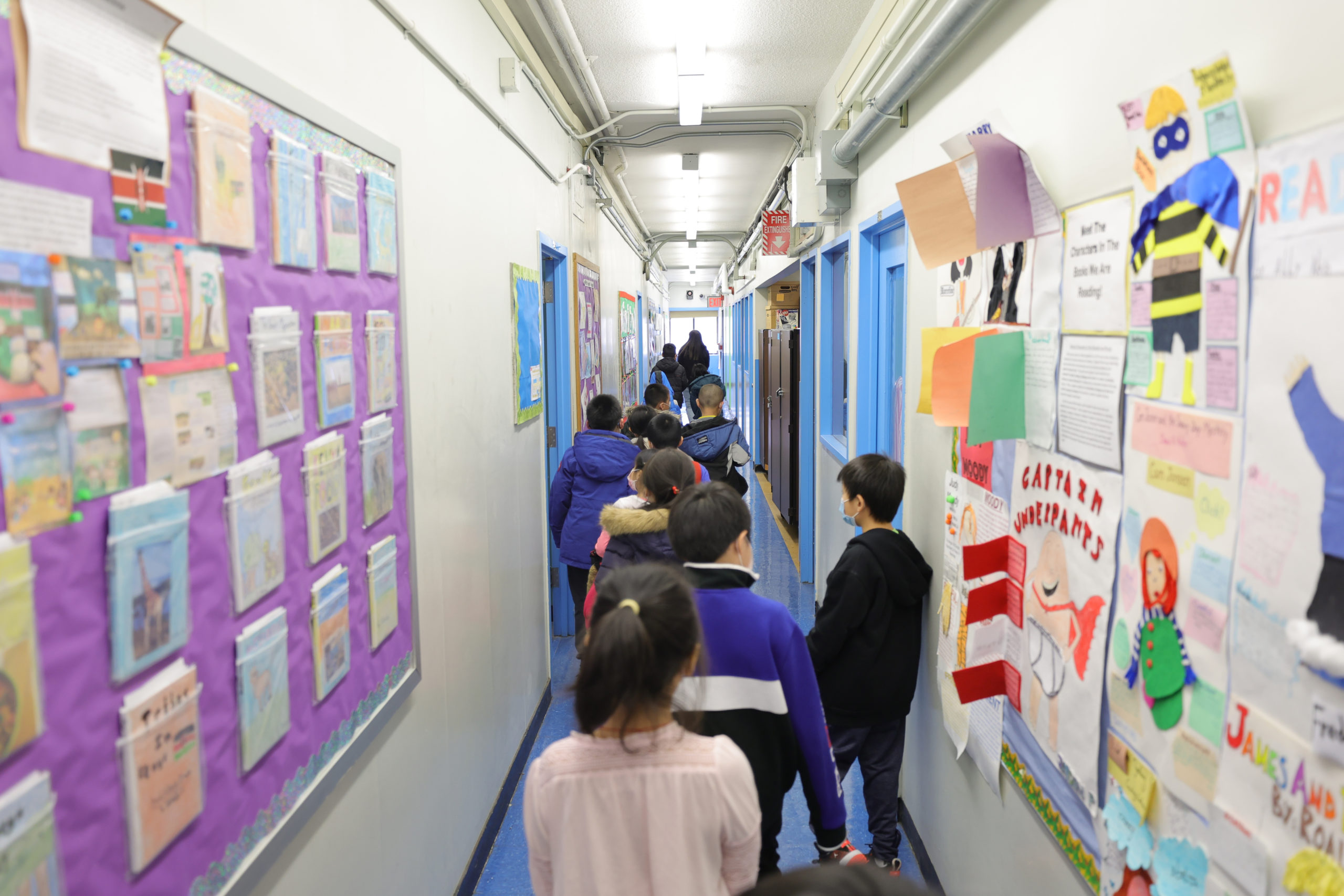 Students are led to their classroom by Marisa Wiezel (who is related to the photographer), a teacher at Yung Wing School P.S. 124 on March 07, 2022 in New York City. (Photo by Michael Loccisano/Getty Images)
