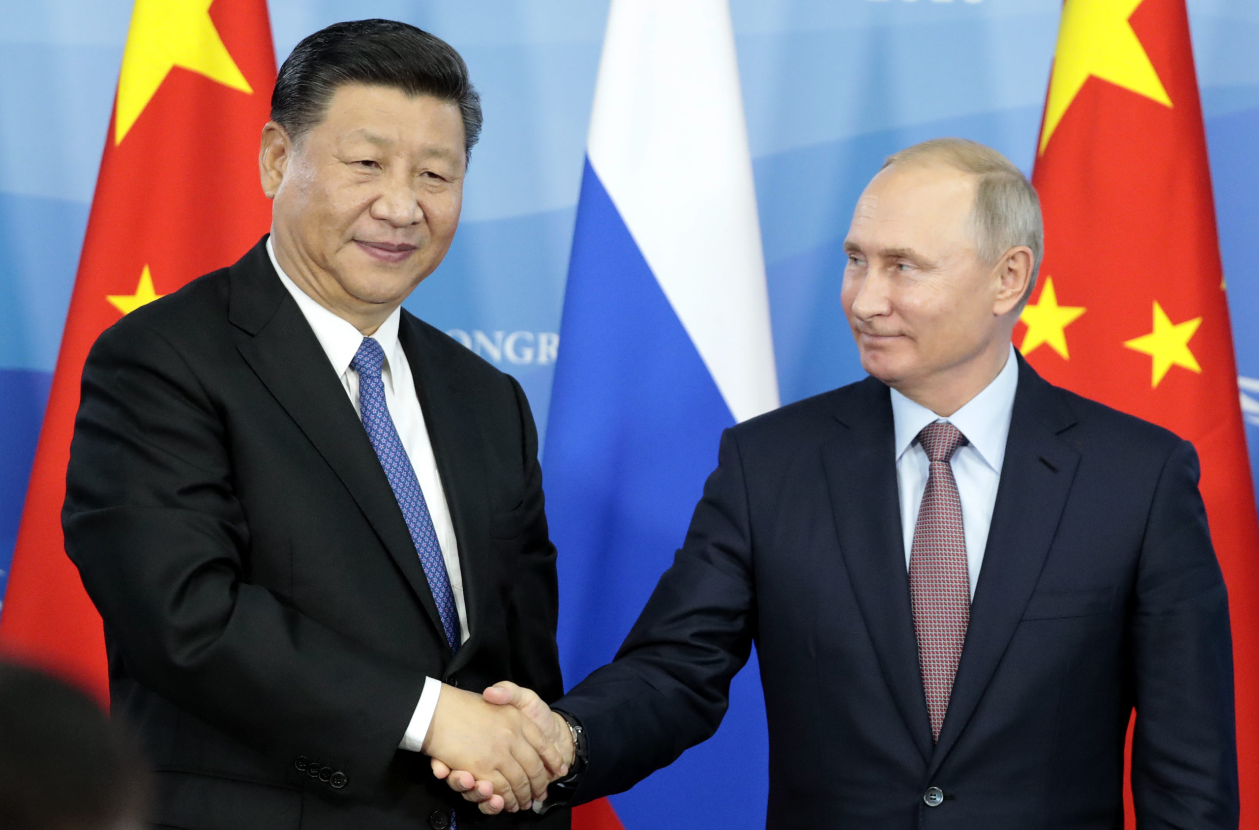 Russia's President Vladimir Putin (R) shakes hands with his China's counterpart Xi Jinping during a signing ceremony following the Russian-Chinese talks on the sidelines of the Eastern Economic Forum in Vladivostok on September 11, 2018. (Photo by SERGEI CHIRIKOV / POOL / AFP) (Photo credit should read SERGEI CHIRIKOV/AFP via Getty Images)