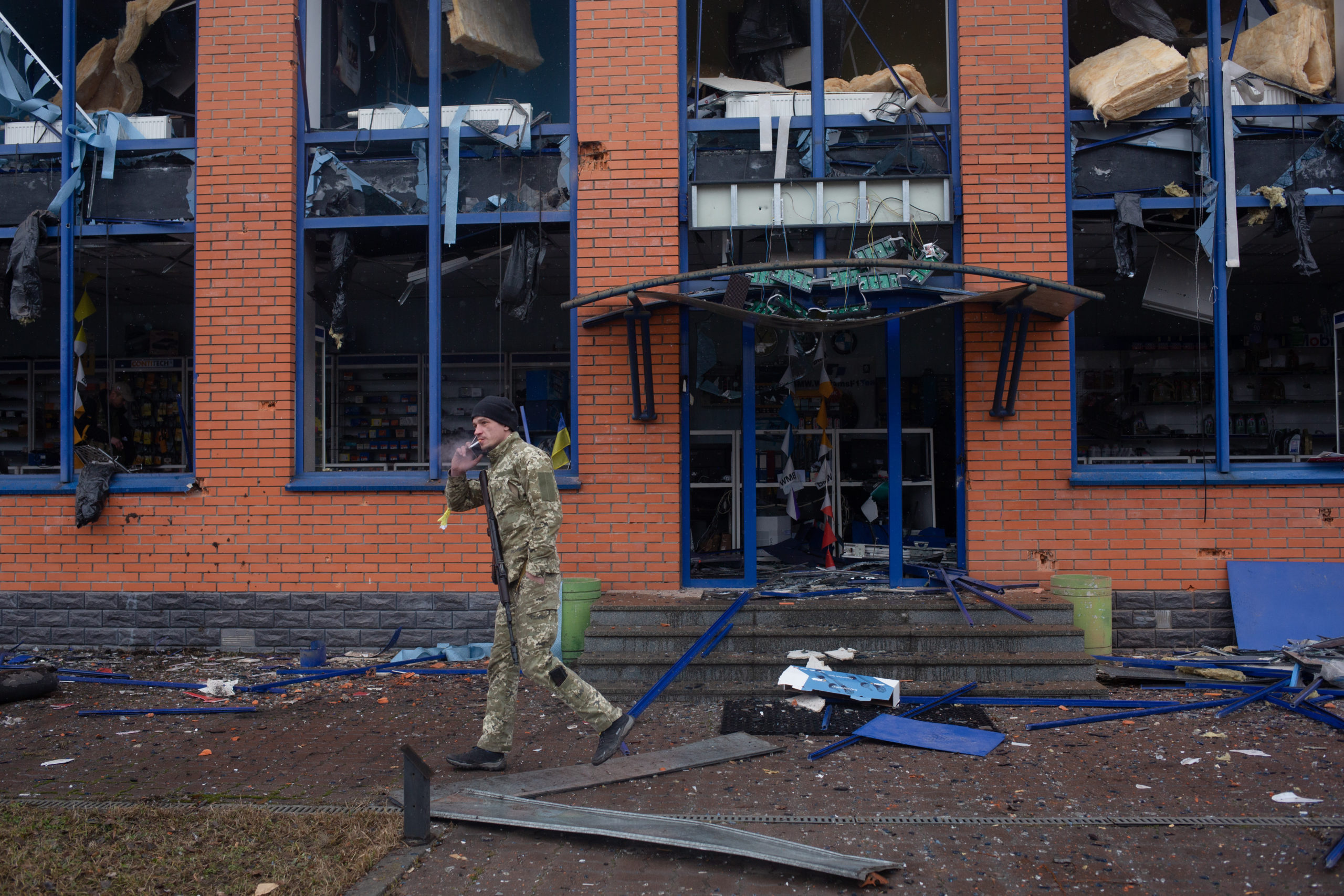 A Ukrainian soldier walks by a shelled store in Kyiv, Ukraine, on Wednesday. (Anastasia Vlasova/Getty Images)