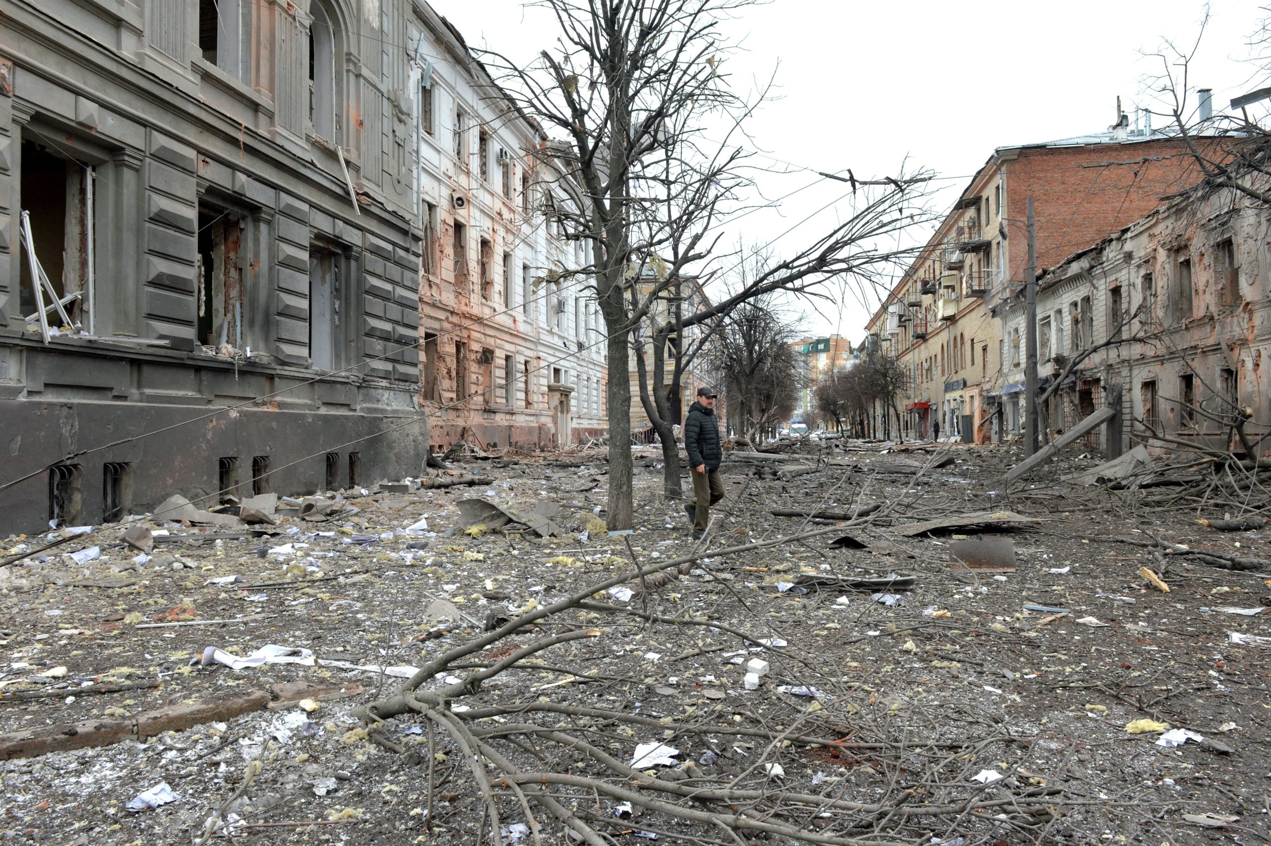TOPSHOT - A pedestrian walks amid debris in a street following a shelling in Ukraine's second-biggest city of Kharkiv on March 7, 2022. - On the 12th day of Russia's invasion of Ukraine March 7, 2022, Russian forces pressed a siege of the key southern port of Mariupol and sought to increase pressure on the capital Kyiv. Kyiv remains under Ukrainian control as does Kharkiv in the east, with the overall Russian ground advance little changed over the last 24 hours in the face of fierce Ukrainian resistance. (Photo by Sergey BOBOK / AFP) (Photo by SERGEY BOBOK/AFP via Getty Images)