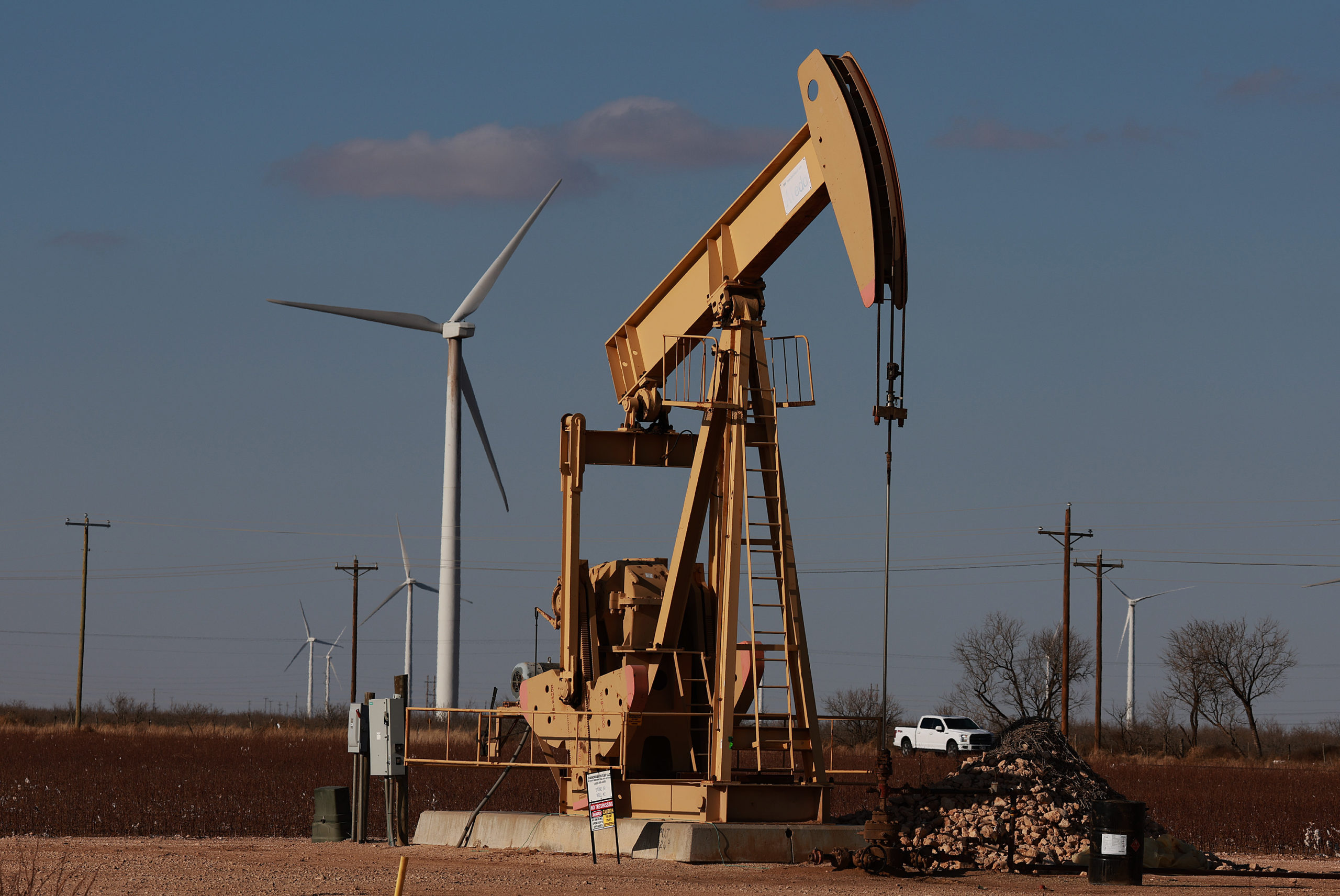 An oil pumpjack works near wind turbines in a Permian Basin oil field on March 11 in Stanton, Texas. (Joe Raedle/Getty Images)