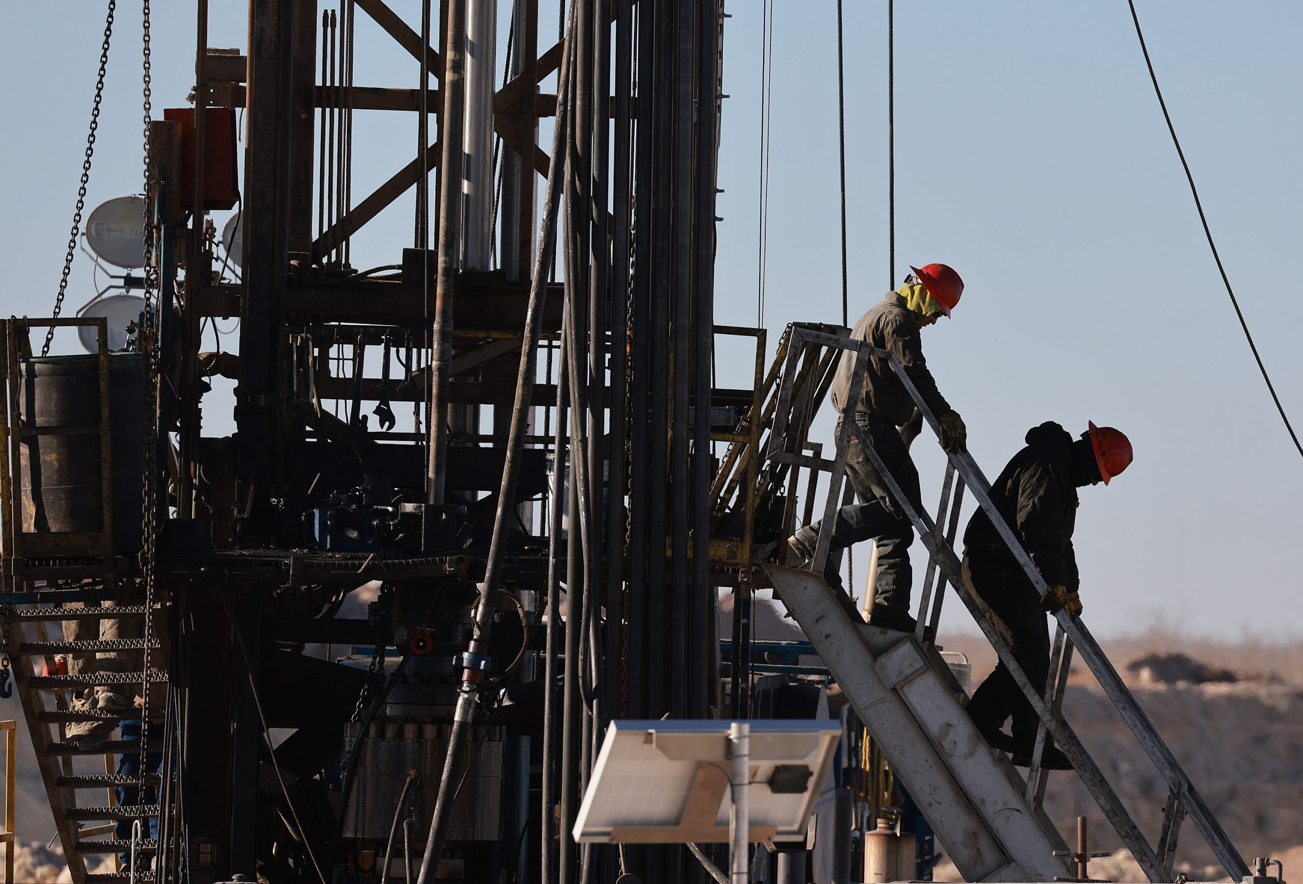 Workers place pipe into the ground on an oil drilling rig in the Permian Basin oil field on March 12 in Midland, Texas. (Joe Raedle/Getty Images)