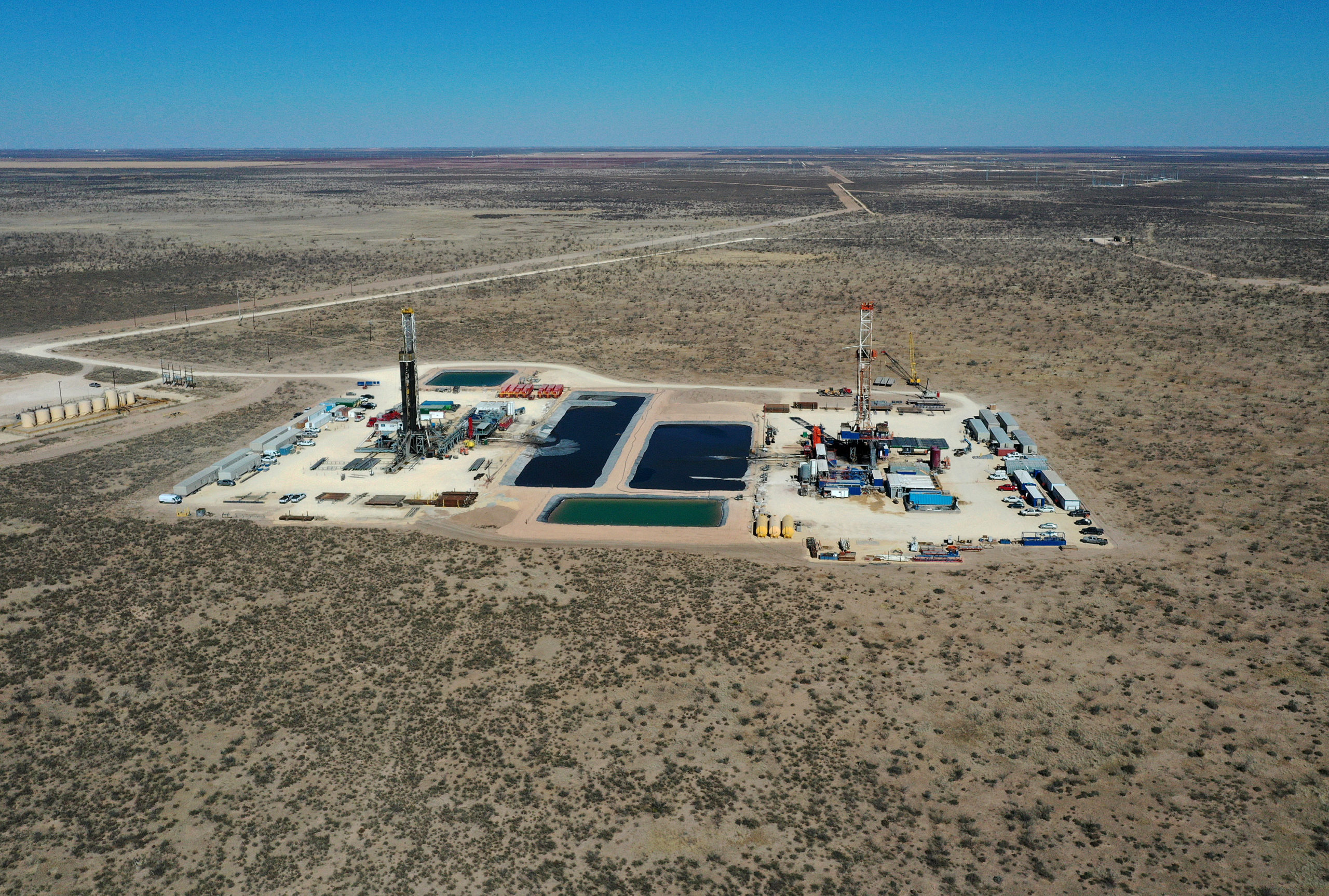 Gli impianti di perforazione petrolifera lavorano nel giacimento petrolifero del bacino del Permiano il 13 marzo a Midland, in Texas.  (Joe Raedle / Getty Images)