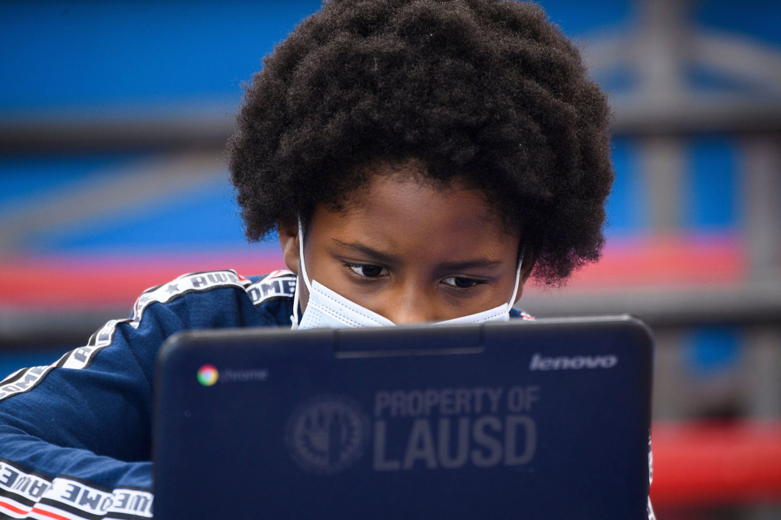 A child wears a face mask as they attend an online class at a learning hub inside the Crenshaw Family YMCA during the Covid-19 pandemic on February 17, 2021 in Los Angeles, California. (Photo by PATRICK T. FALLON/AFP via Getty Images)