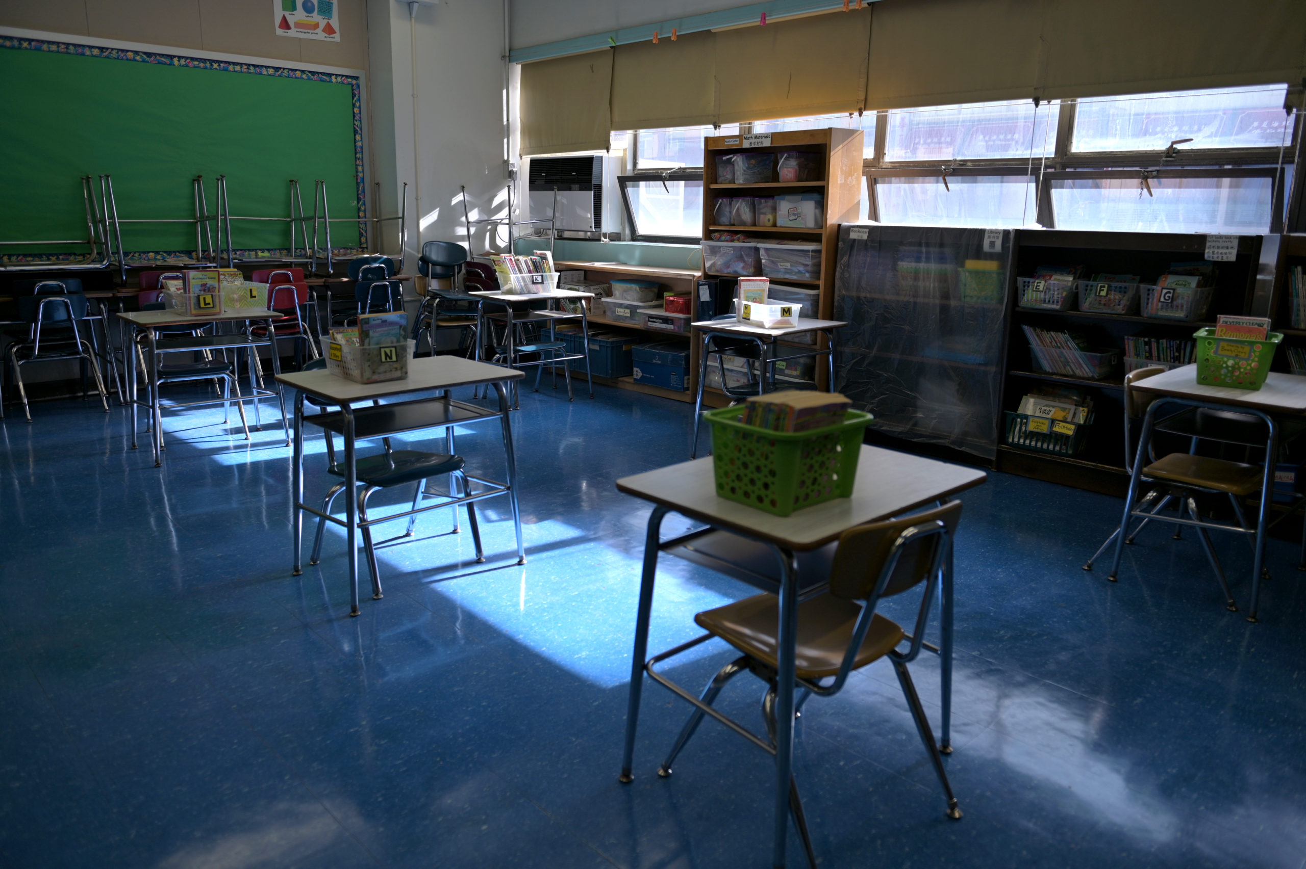 A classroom is empty with the lights off on what would otherwise be a blended learning school day on November 19, 2020 at Yung Wing School P.S. 124 in New York City. NYC Mayor Bill DeBlasio had to return the nation’s largest district had to all-remote teaching/learning as of today, with an indefinite outlook for reopening. (Photo by Michael Loccisano/Getty Images)