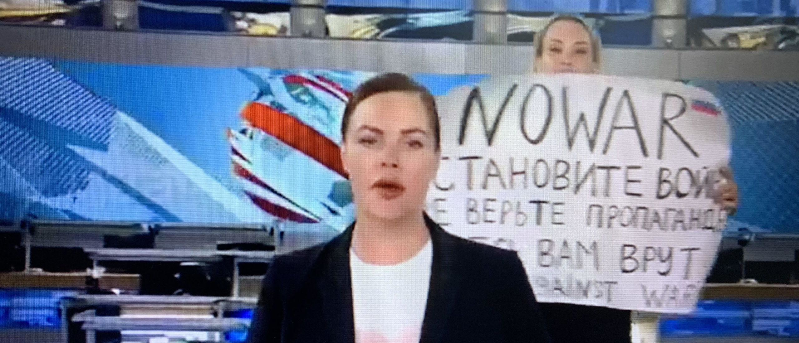 Новости первый канал 21 февраля 2024. Прямой эфир первого канала. Женщина с плакатом в прямом эфире.