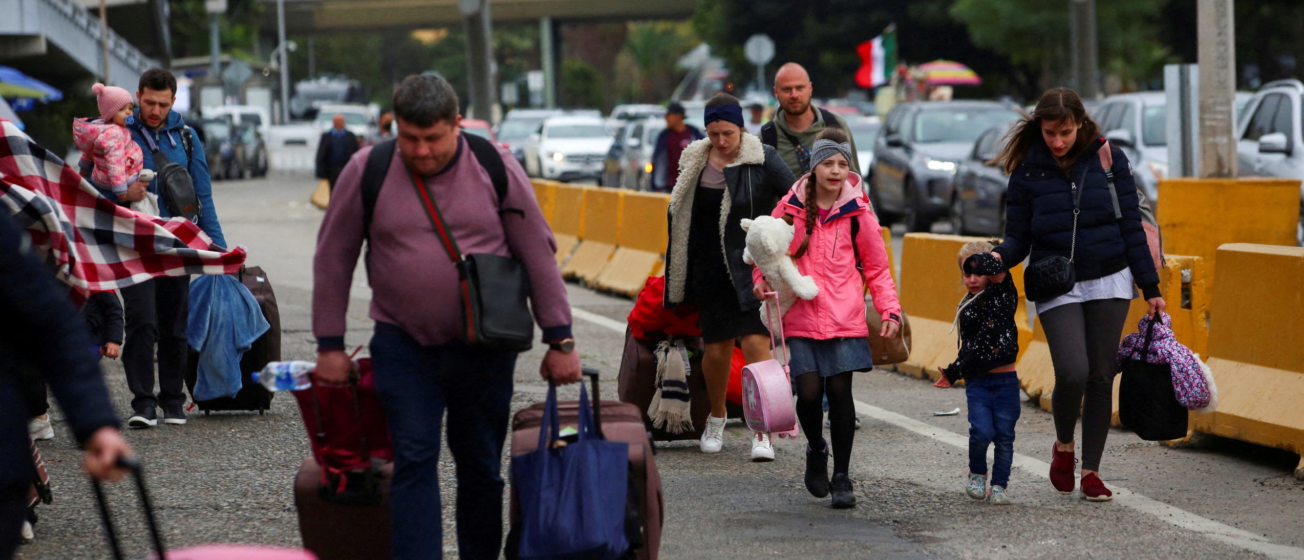 FILE PHOTO: Ukrainians who fled to Mexico amid Russia's invasion of their homeland, walk with their belongings to cross the San Ysidro Land Port of Entry of the U.S.-Mexico border, in Tijuana, Mexico April 2, 2022. REUTERS/Jorge Duenes/File Photo