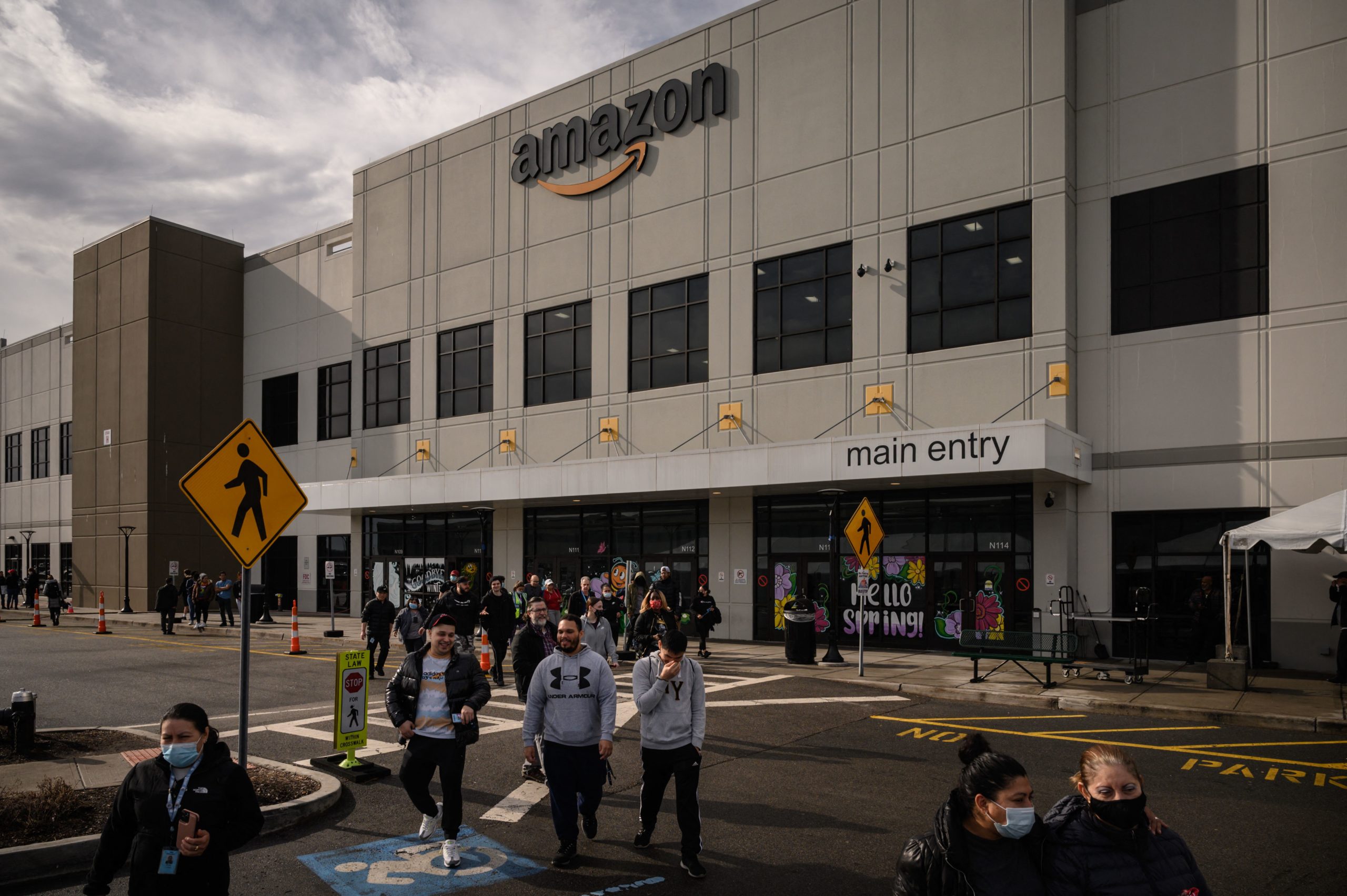 Workers walk to cast their votes over whether or not to unionize, outside an Amazon warehouse in Staten Island on March 25, 2022. (Photo by ED JONES/AFP via Getty Images)