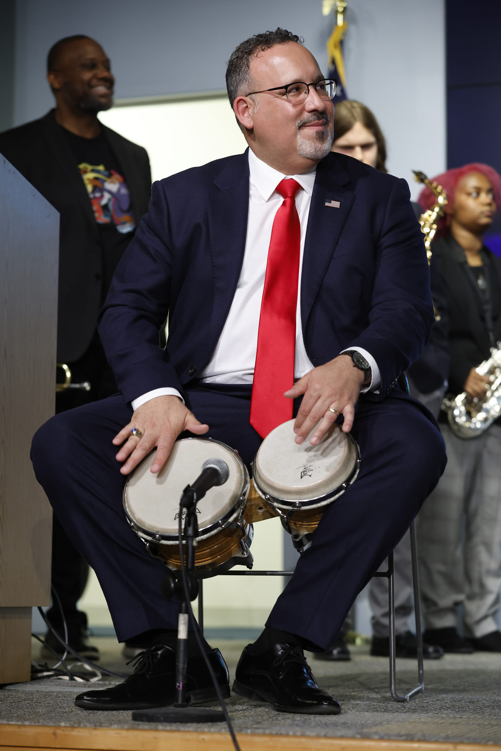 U.S. Education Secretary Miguel Cardona plays Latin percussion while performing with members of the high school-age Herbie Hancock Jazz Institute Peer-To-Peer Jazz Sextet at the department's Lyndon B. Johnson headquarters building on April 19, 2022 in Washington, DC. (Photo by Chip Somodevilla/Getty Images)